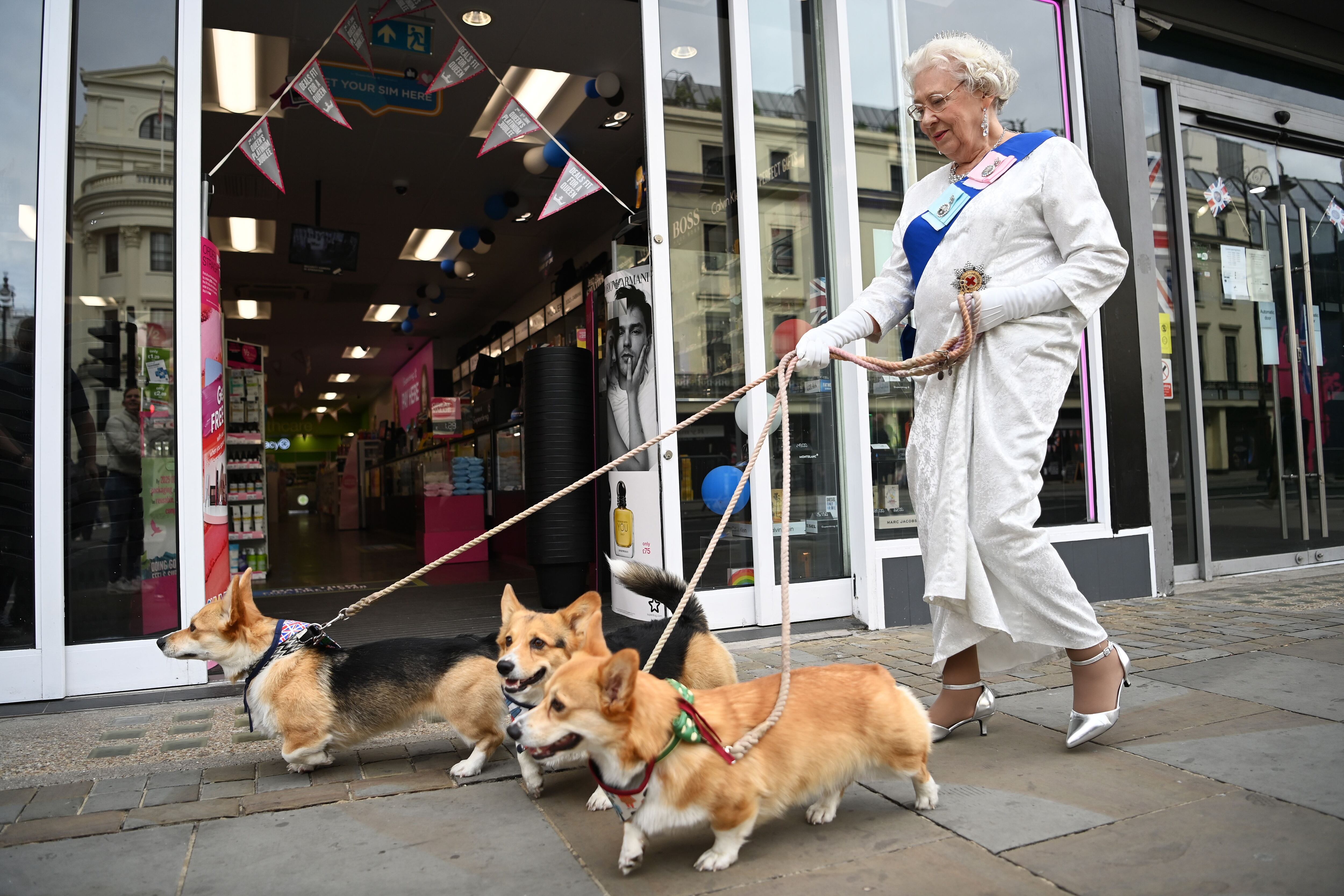 Imagen de archivo de una imitadora de Isabel II y sus perros paseando por Londres. EFE/EPA/ANDY RAIN 