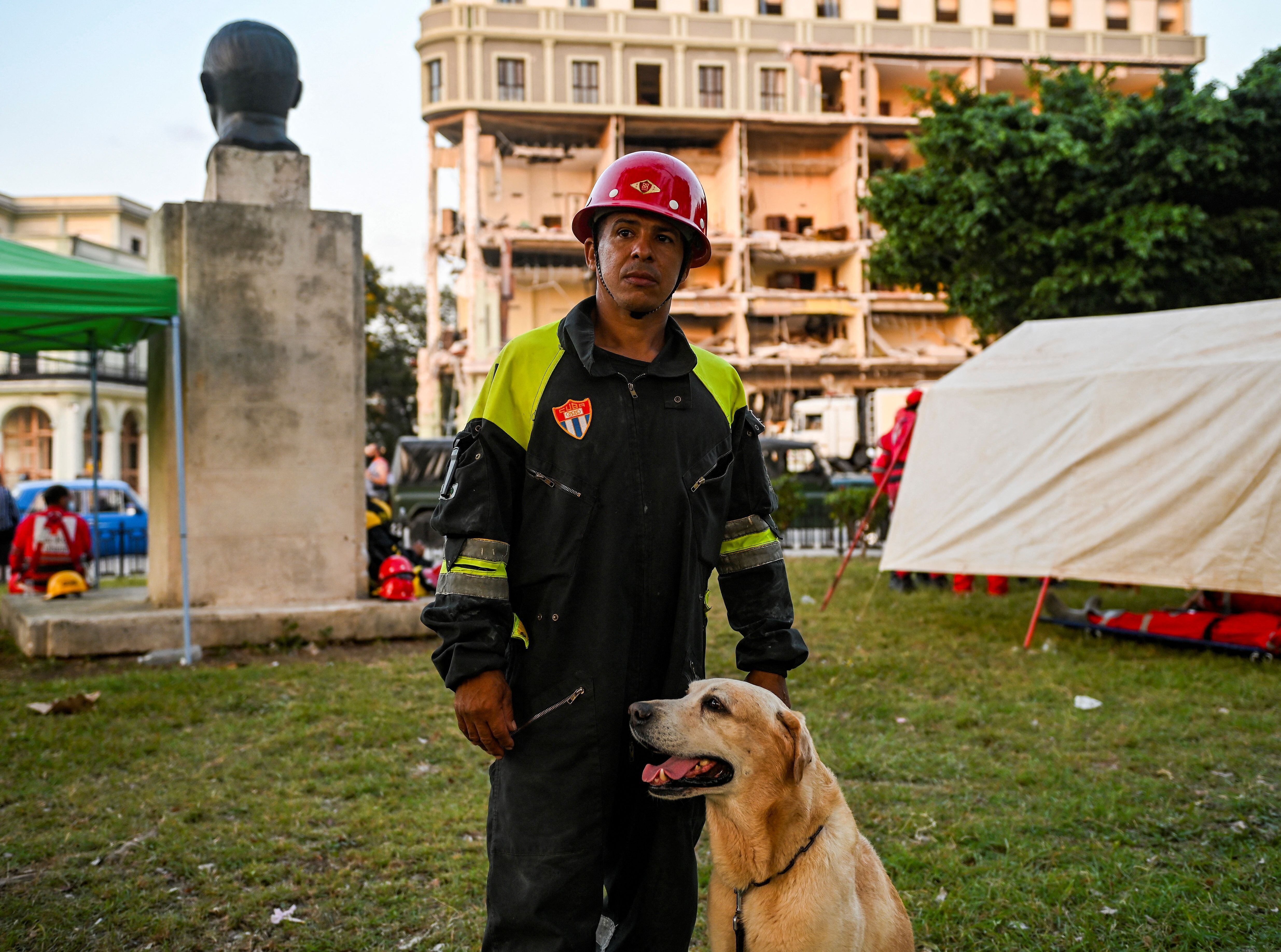 El técnico canino Edel Llopiz posa para una foto cerca del Hotel Saratoga en La Habana, el 9 de mayo de 2022, días después de una explosión que ha dejado 42 muertos, incluidos cuatro niños y 54 heridos, de los cuales 17 permanecen en el hospital. (Foto de YAMIL LAGE / AFP)