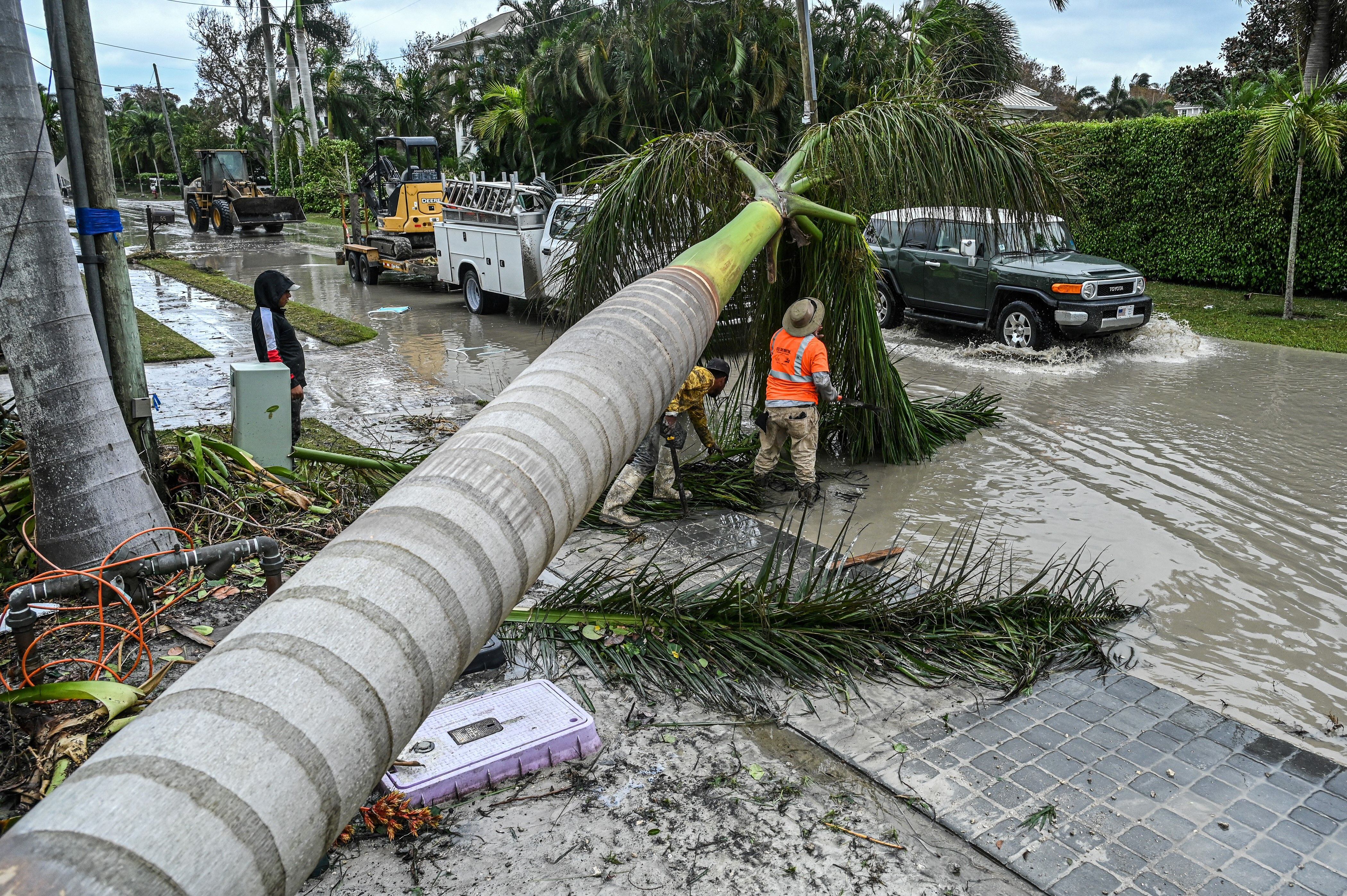 Los trabajadores limpian escombros y árboles caídos después del paso del huracán Ian en Naples, Florida, el 29 de septiembre de 2022.