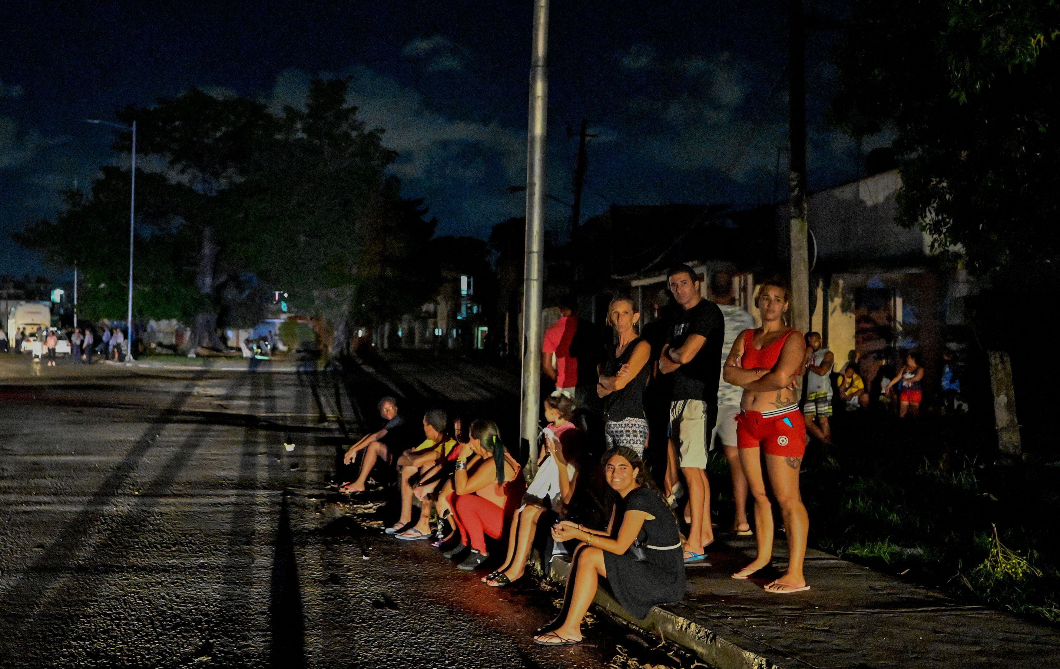 Residentes se reúnen afuera en un vecindario en medio de un apagón eléctrico prolongado después del huracán Ian en La Habana el 30 de septiembre de 2022. El huracán Ian sumió a toda Cuba en la oscuridad después de derribar la red eléctrica de la isla.