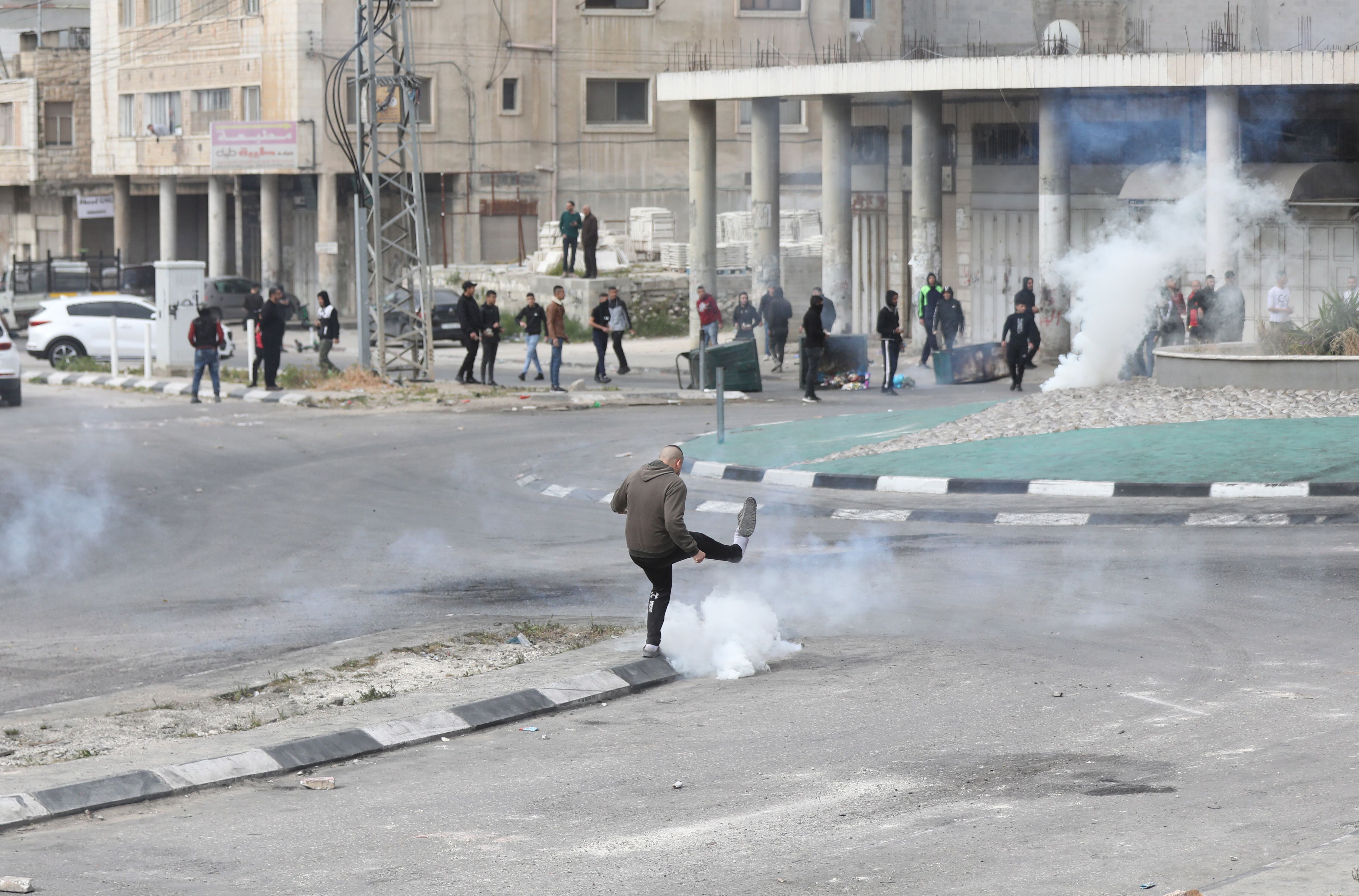 Un palestino patea una granada de gas lacrimogeno durante un enfrentamiento con las tropas israelíes en la ciudad cisjordana de Nablus, en una imagen de archivo. EFE/ Alaa Badarneh 
