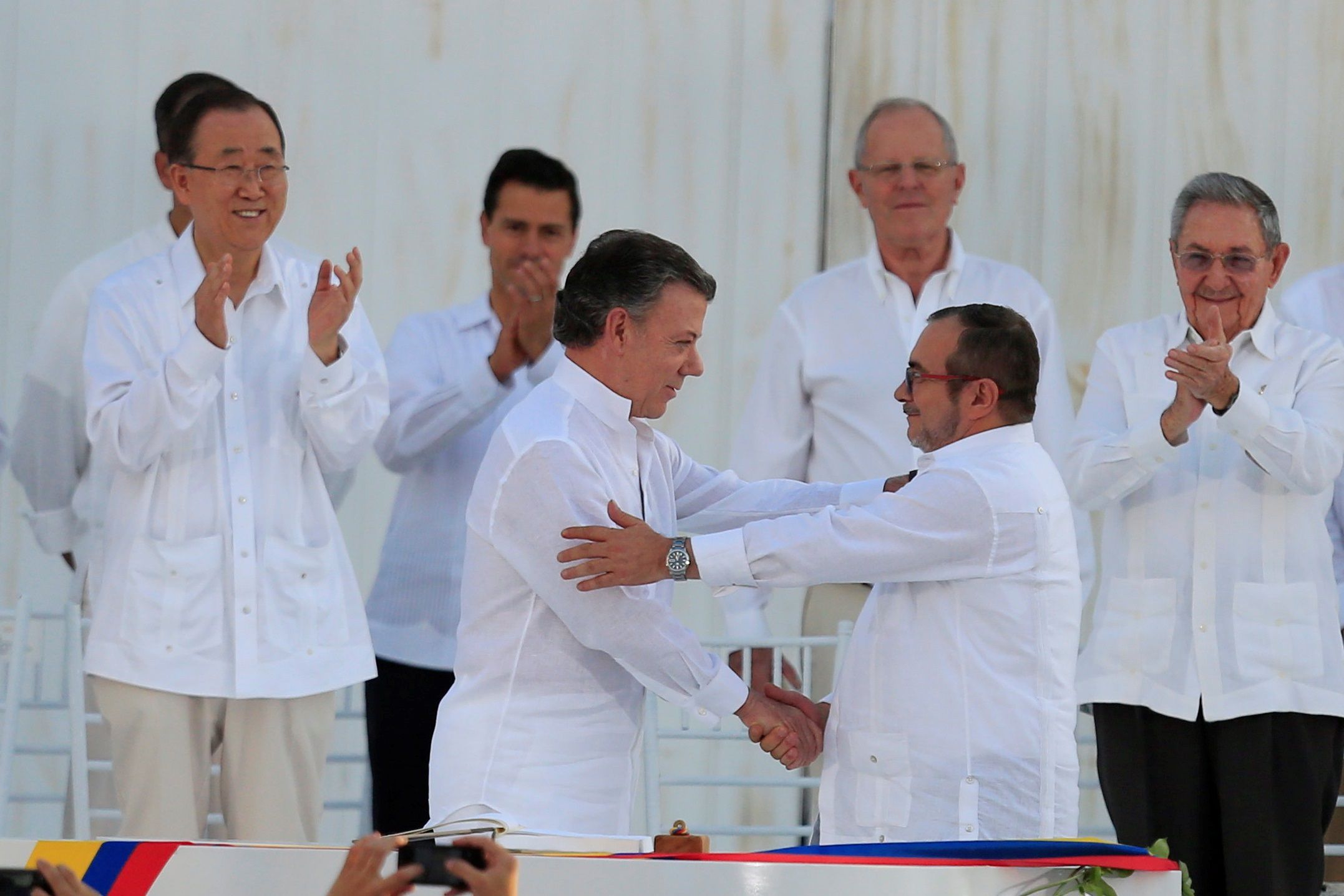 El presidente de Colombia, Juan Manuel Santos (c-i), y el máximo líder de las FARC, Rodrigo Londoño(c-d), alias Timochenko, se saludan tras firmar el acuerdo de paz, el 26 de septiembre de 2016, en Cartagena (Colombia). 
