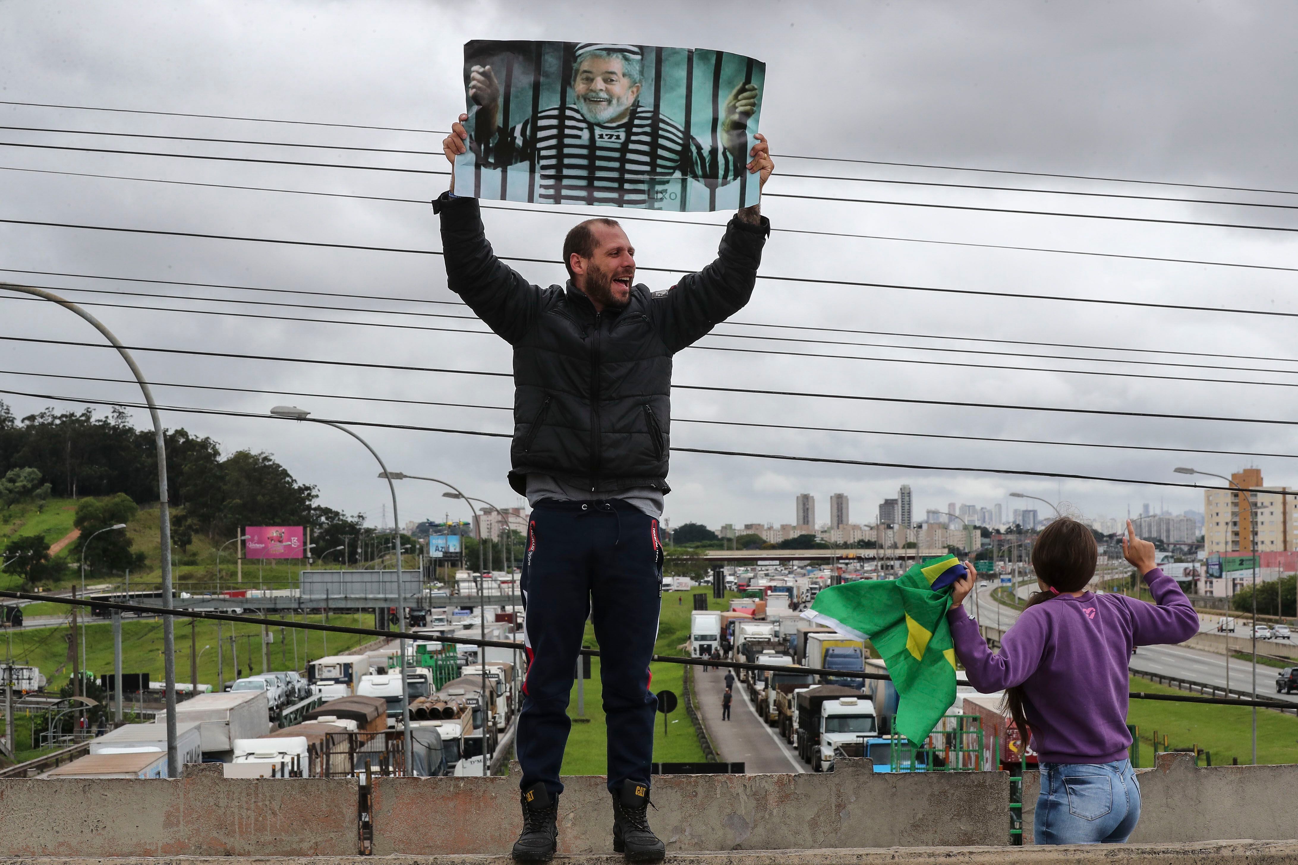 Un manifestante sostiene una imagen del líder progresista Luiz Inácio Lula da Silva durante un bloqueo de camioneros en la carretera Castello Branco, como protesta tras la derrota del presidente, Jair Bolsonaro, en Barueri (Brasil). 