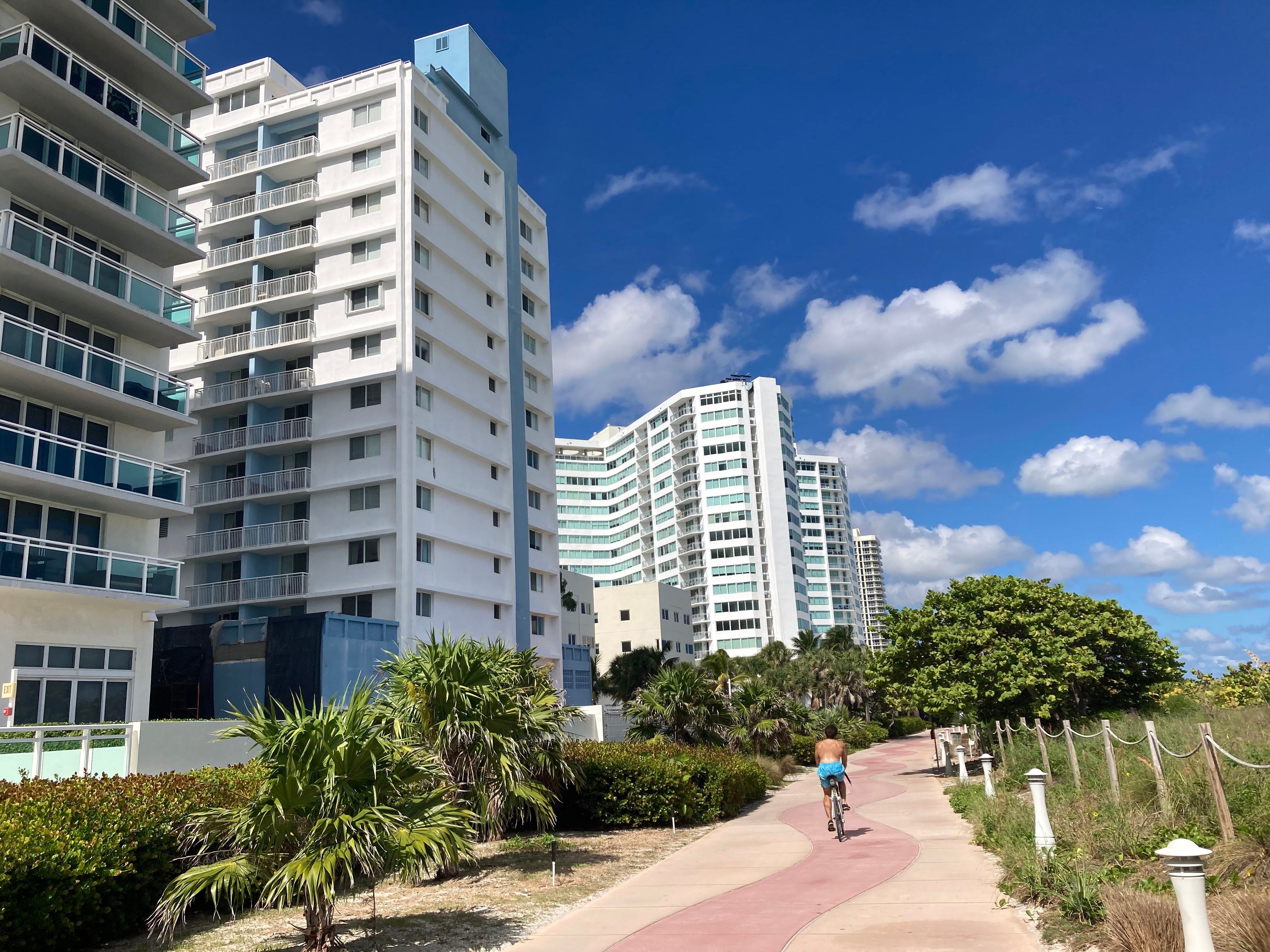 Una persona monta hoy en bicicleta junto a la parte trasera del edificio de 14 plantas The Port Royale en Miami Beach, Florida (EE.UU). EFE/Ivonne Malaver 