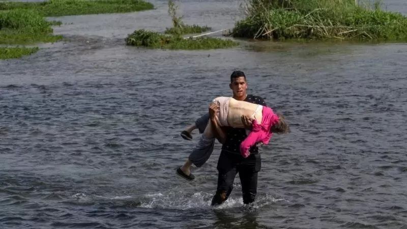 En mayo de 2021, esta foto circuló ampliamente por internet. Una anciana venezolana cruzó en brazos de un joven el río Bravo desde México a EE.UU. REUTERS