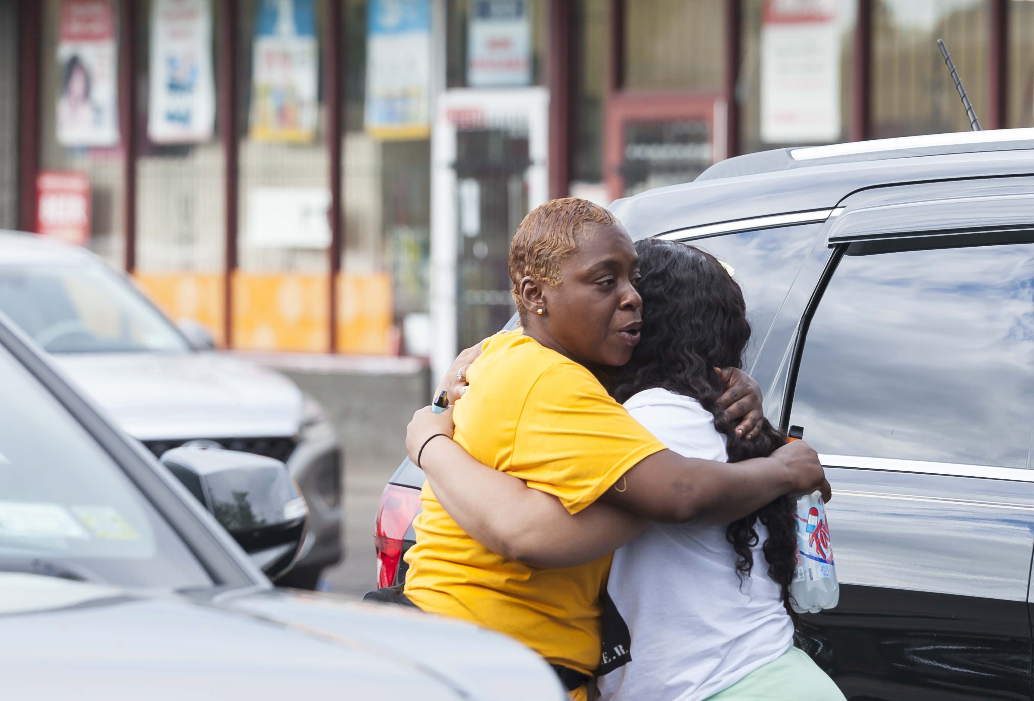 Dos personas se abrazan cerca de la escena de un tiroteo masivo en una tienda de Tops Friendly Market en Búfalo, Nueva York (EE.UU.), este 14 de mayo de 2022. EFE/EPA/Brandon Watson 