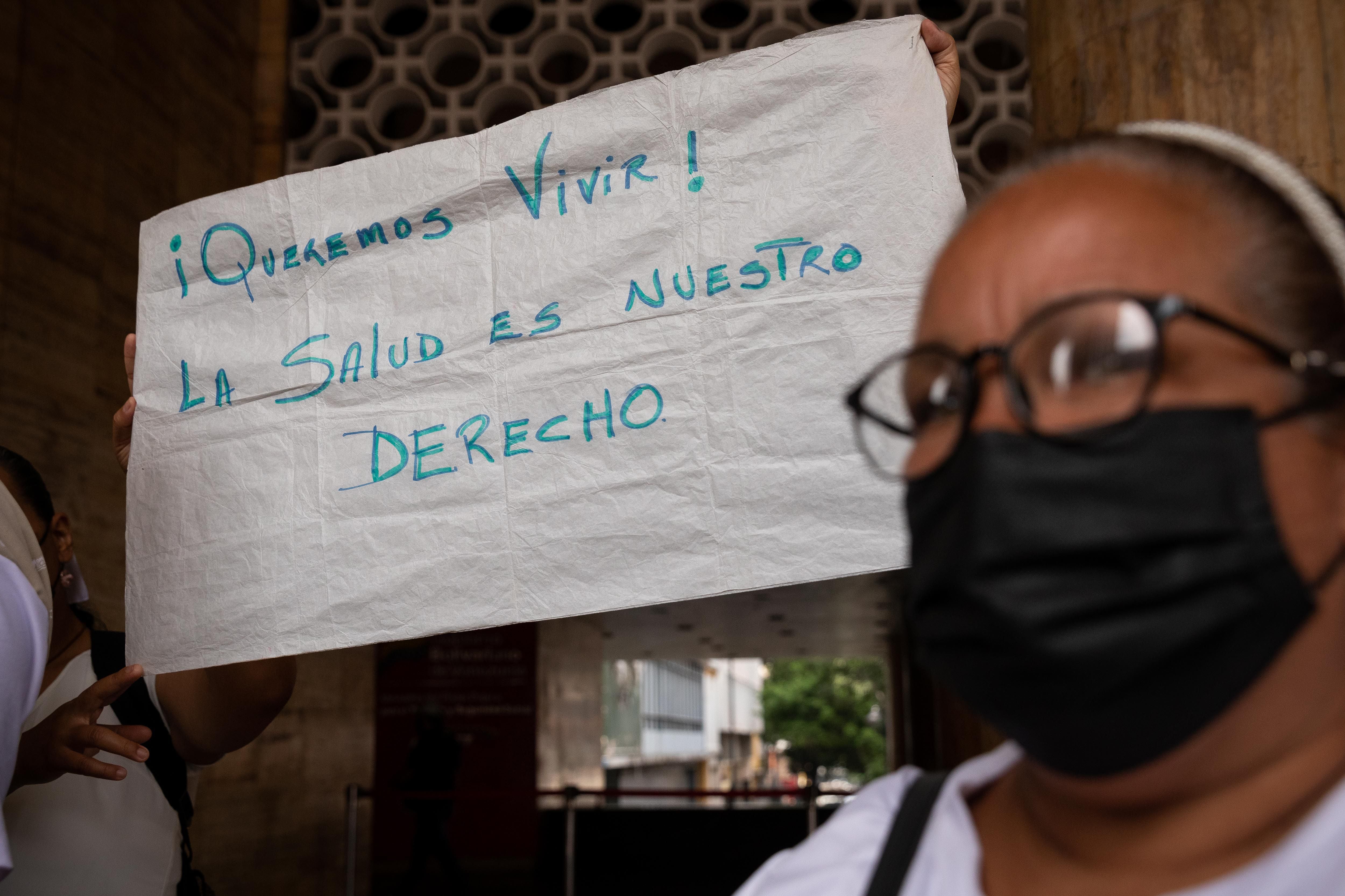 AME6991. CARACAS (VENEZUELA), 05/05/2022.-Pacientes oncológicos sostienen una pancarta que dice "¡Queremos vivir! La salud es nuestro derecho, durante una protesta frente al Ministerio de Salud hoy, en Caracas (Venezuela). EFE/ Rayner Peña R. 