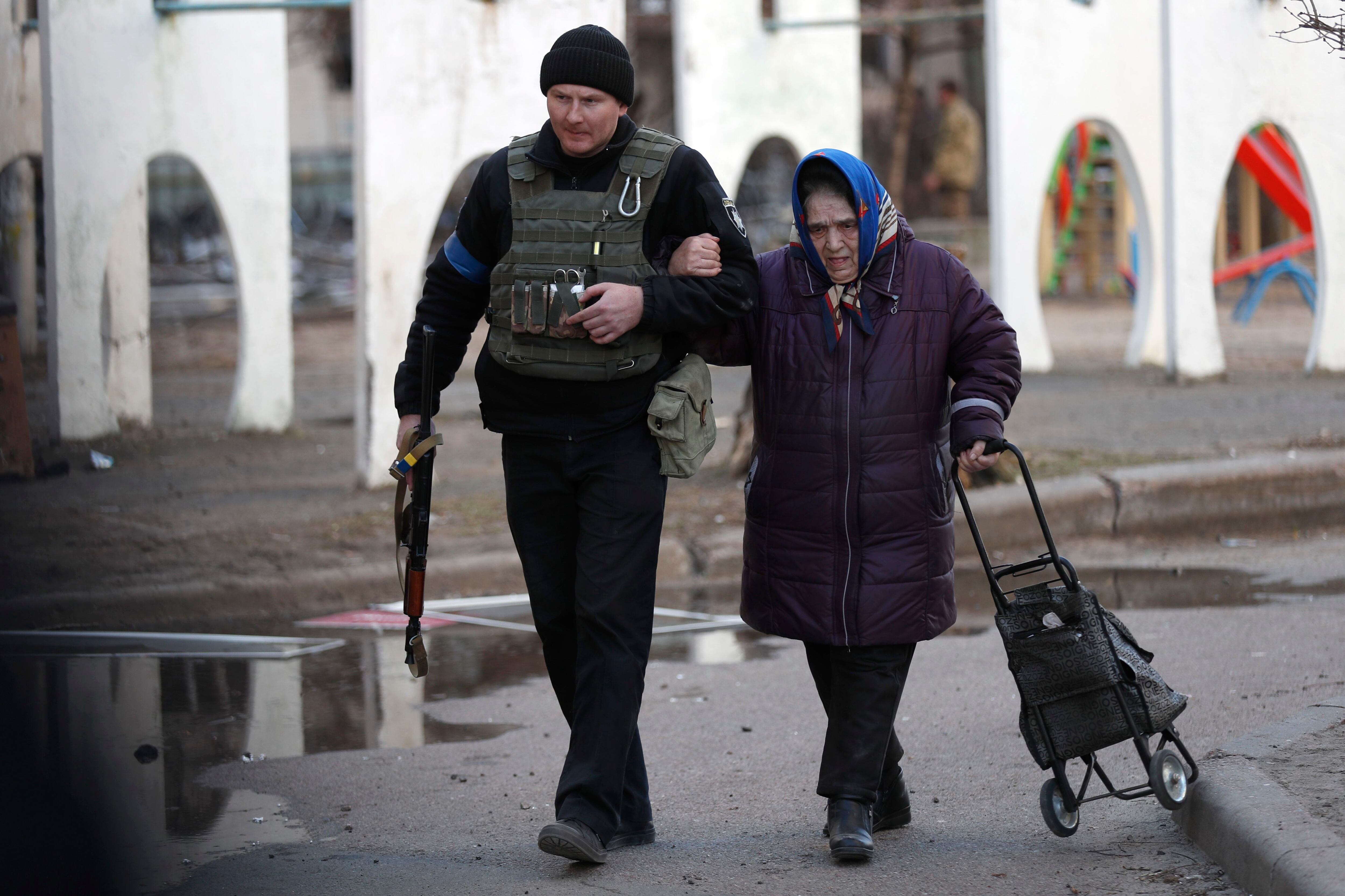 Un policía ucraniano ayuda a evacuar a una mujer de un edificio alcanzado por misiles rusos este domingo. El 24 de febrero las tropas rusas entraron en territorio ucraniano en lo que el presidente ruso declaró "una operación militar especial", que ha provocado un enorme flujo de refugiados, combates, destrucciones en el país y múltiples sanciones contra Rusia. EFE/ Atef Safadi 