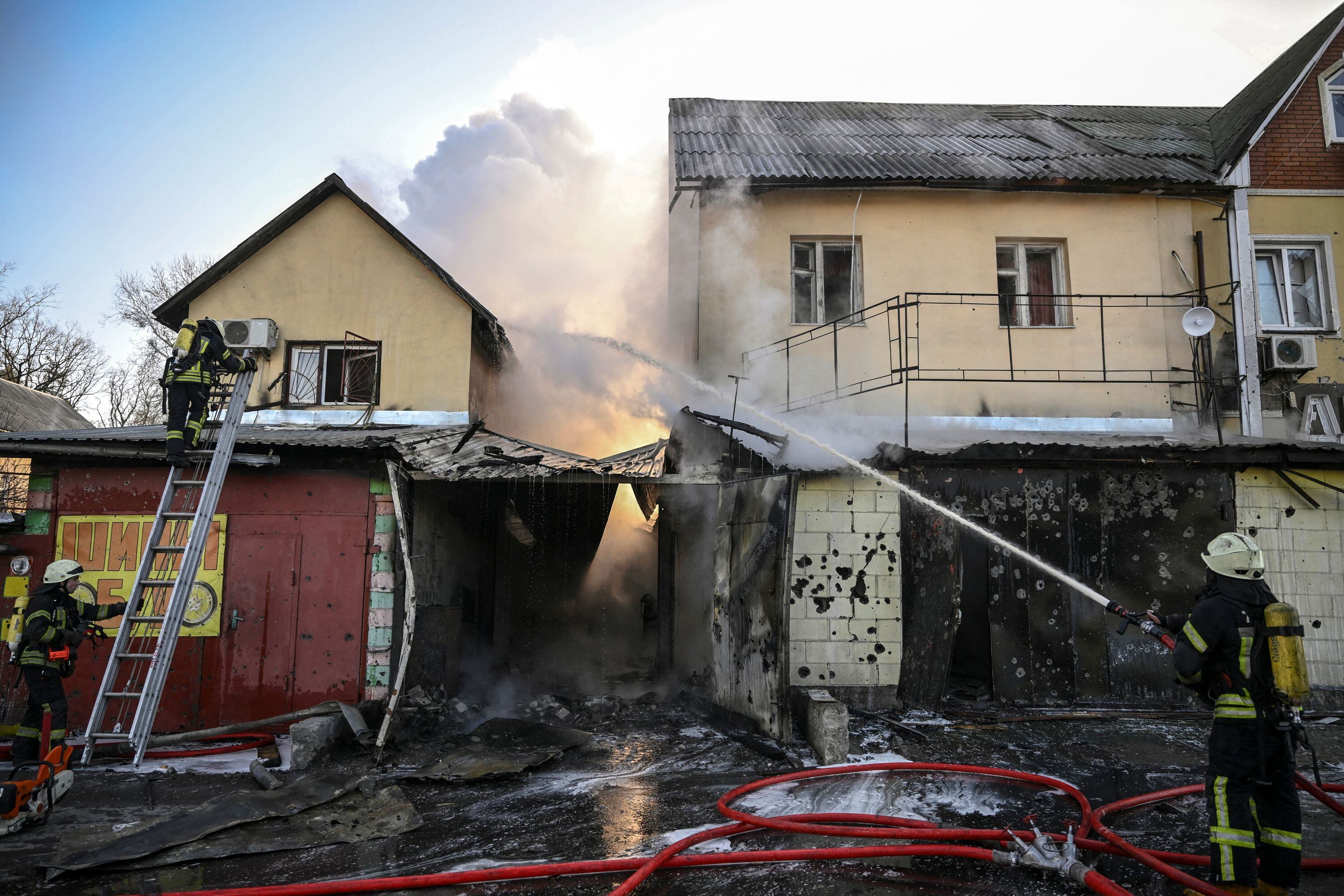 Los bomberos extinguen un incendio en una casa bombardeada el día 17 de la invasión rusa de Ucrania. Las fuerzas rusas están posicionadas alrededor de Kiev el 12 de marzo de 2022 y están "bloqueando" Mariúpol.Foto de Aris Messinis / AFP