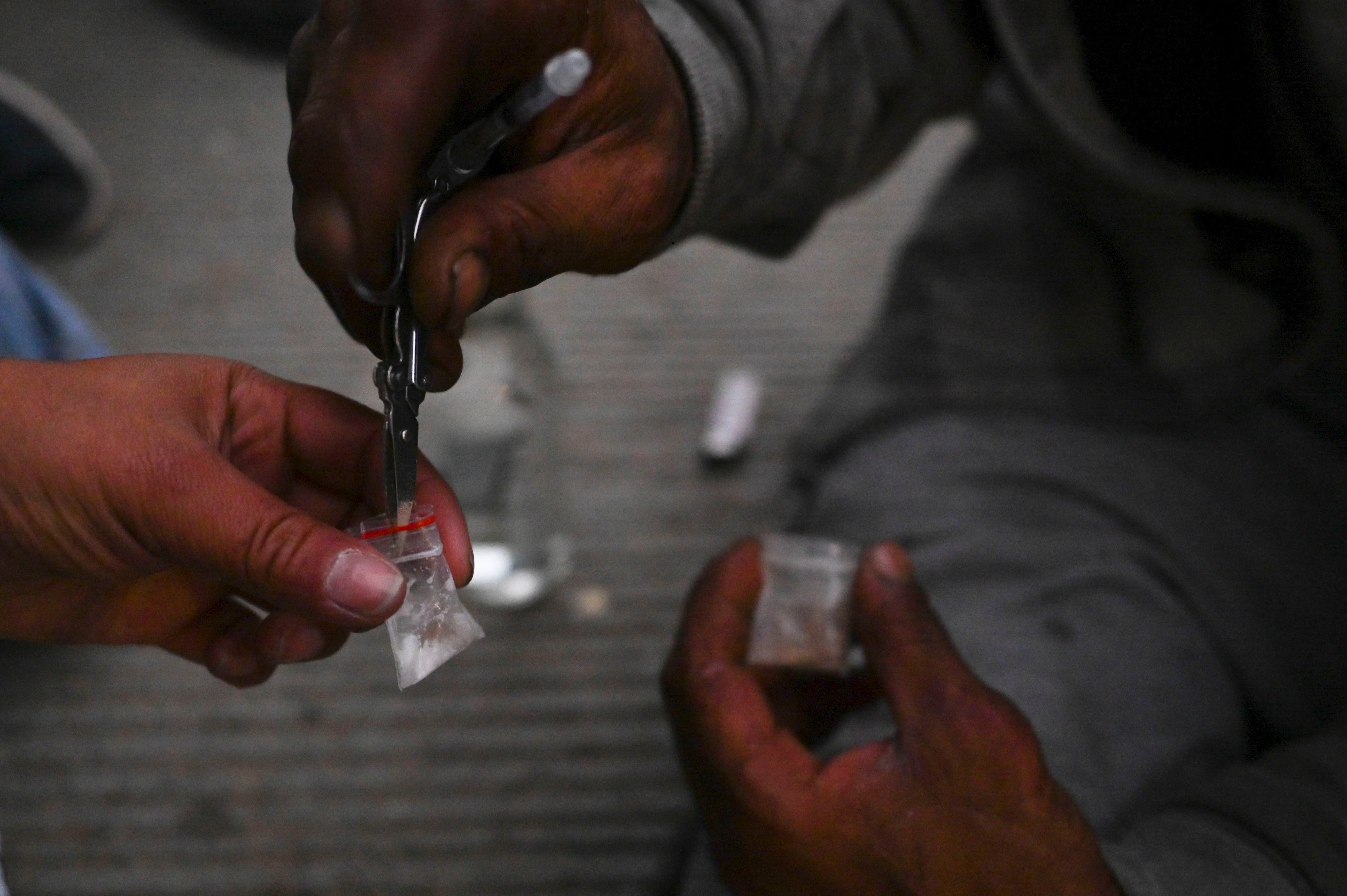 Los drogadictos preparan una dosis de Speedball, una mezcla de heroína y cocaína, en el centro de Medellín, Colombia.