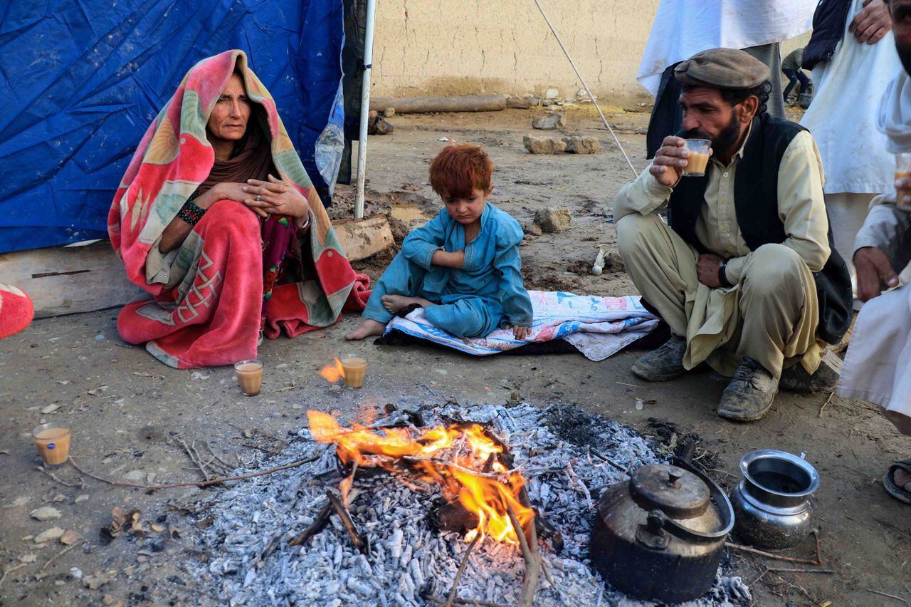 Afganos se calientan alrededor de un fuego fuera de su casa destruida tras un terremoto en la aldea de Gayan en la provincia de Paktia, Afganistán, el 23 de junio de 2022. EFE/EPA/STRINGER