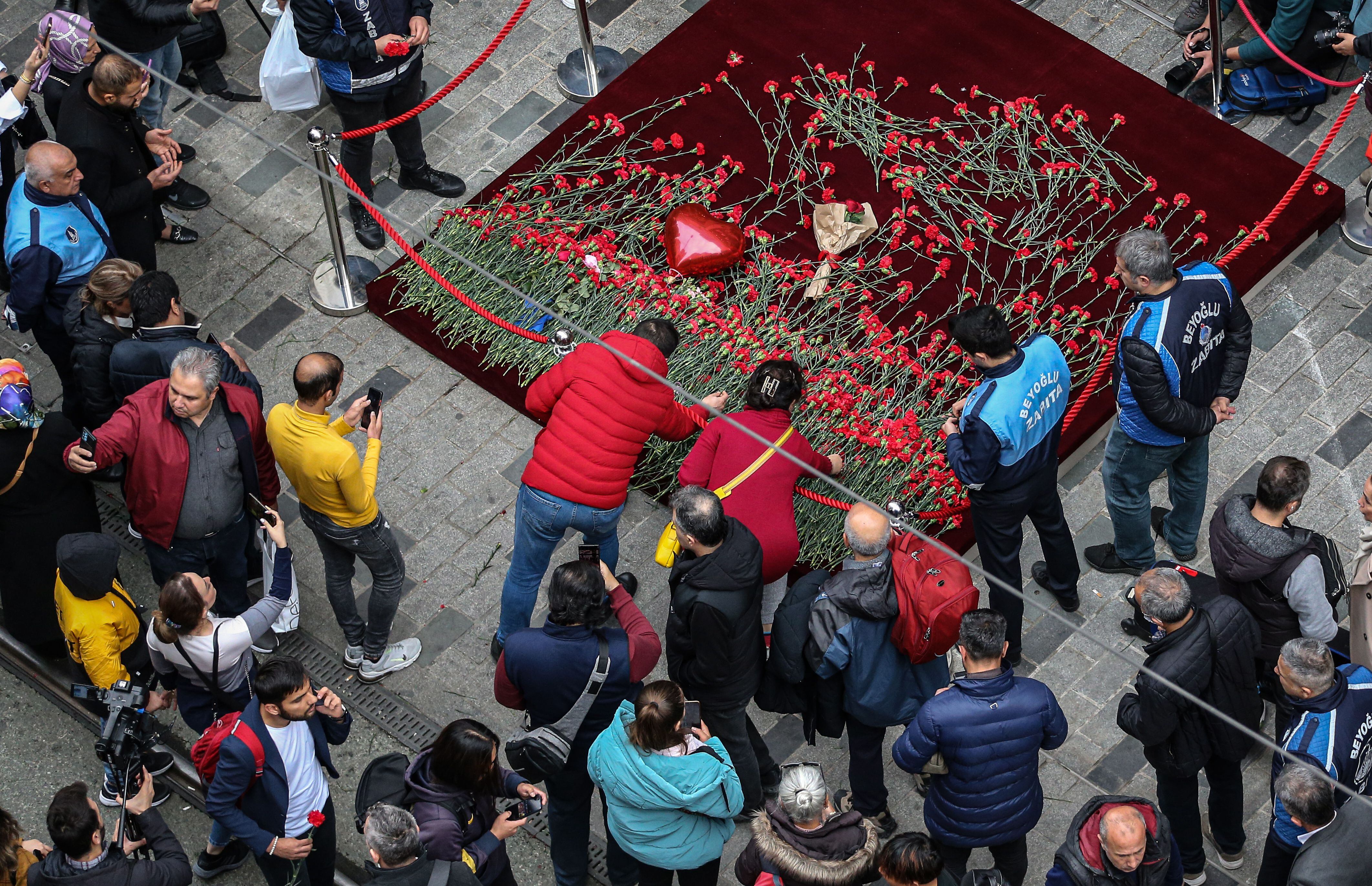 Personas depositan flores en la zona de una explosión mortal el día anterior en la calle Istiklal de Estambul, Turquía, 14 de noviembre de 2022.