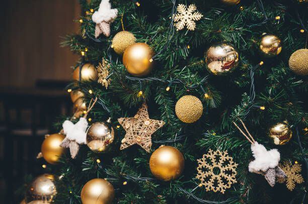 El dorado y el blanco se complementan para la decoración de un árbol navideño.