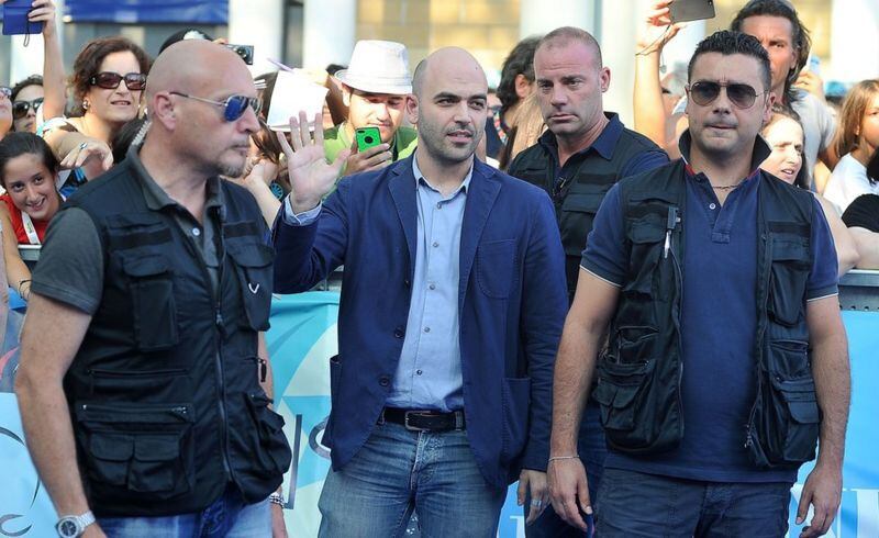 Tres guardaespaldas protegen al periodista Roberto Saviano (centro), quien ha recibido amenazas de muerte por la publicación de su libro "Gomorra", que trata de la mafia napolitana. GETTY IMAGES