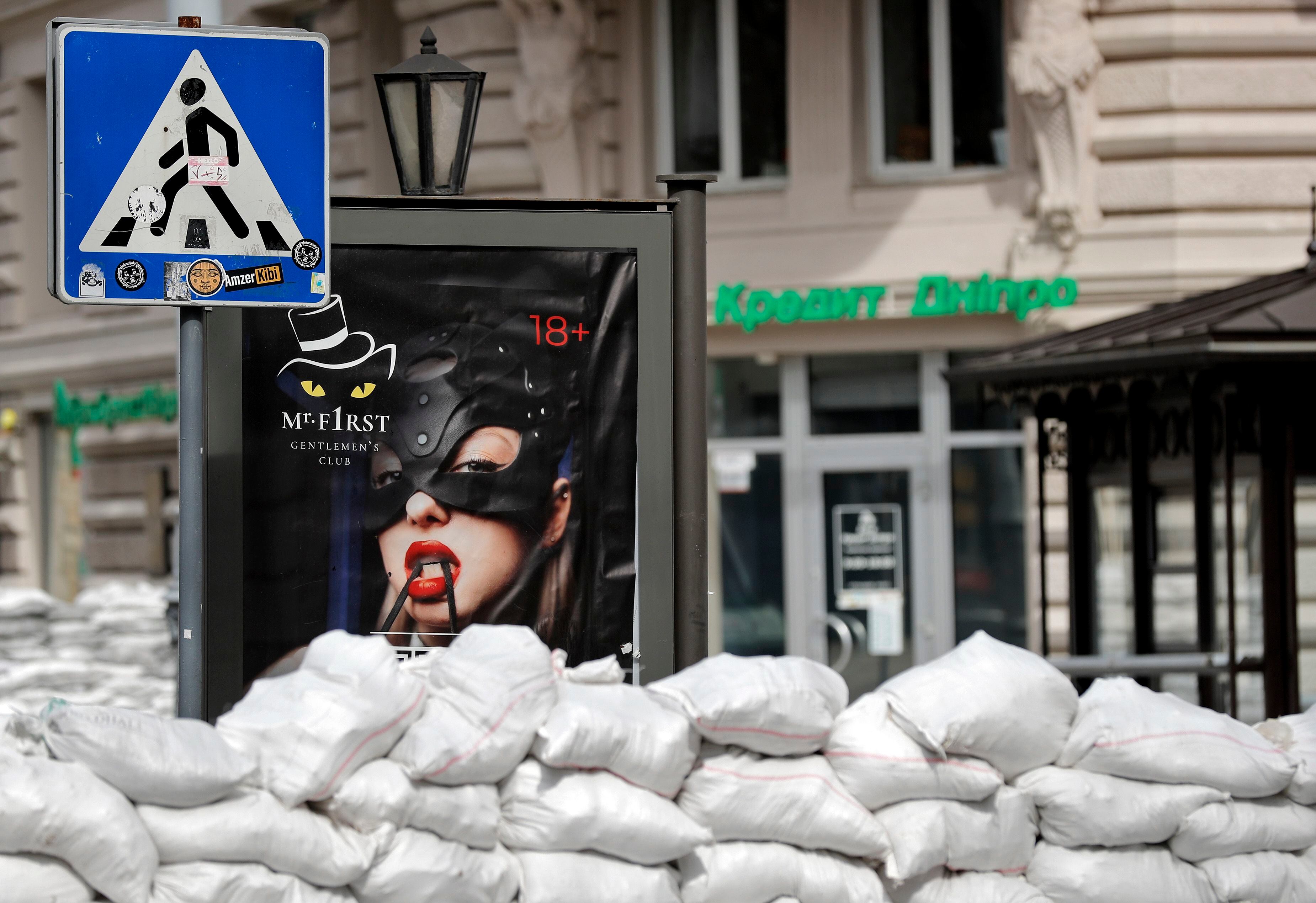 Un cartel publicitario de un club de 'striptease' se entrevé entre los sacos que bloquean una calle de la ciudad ucraniana de Odesa. EFE/Manuel Bruque 