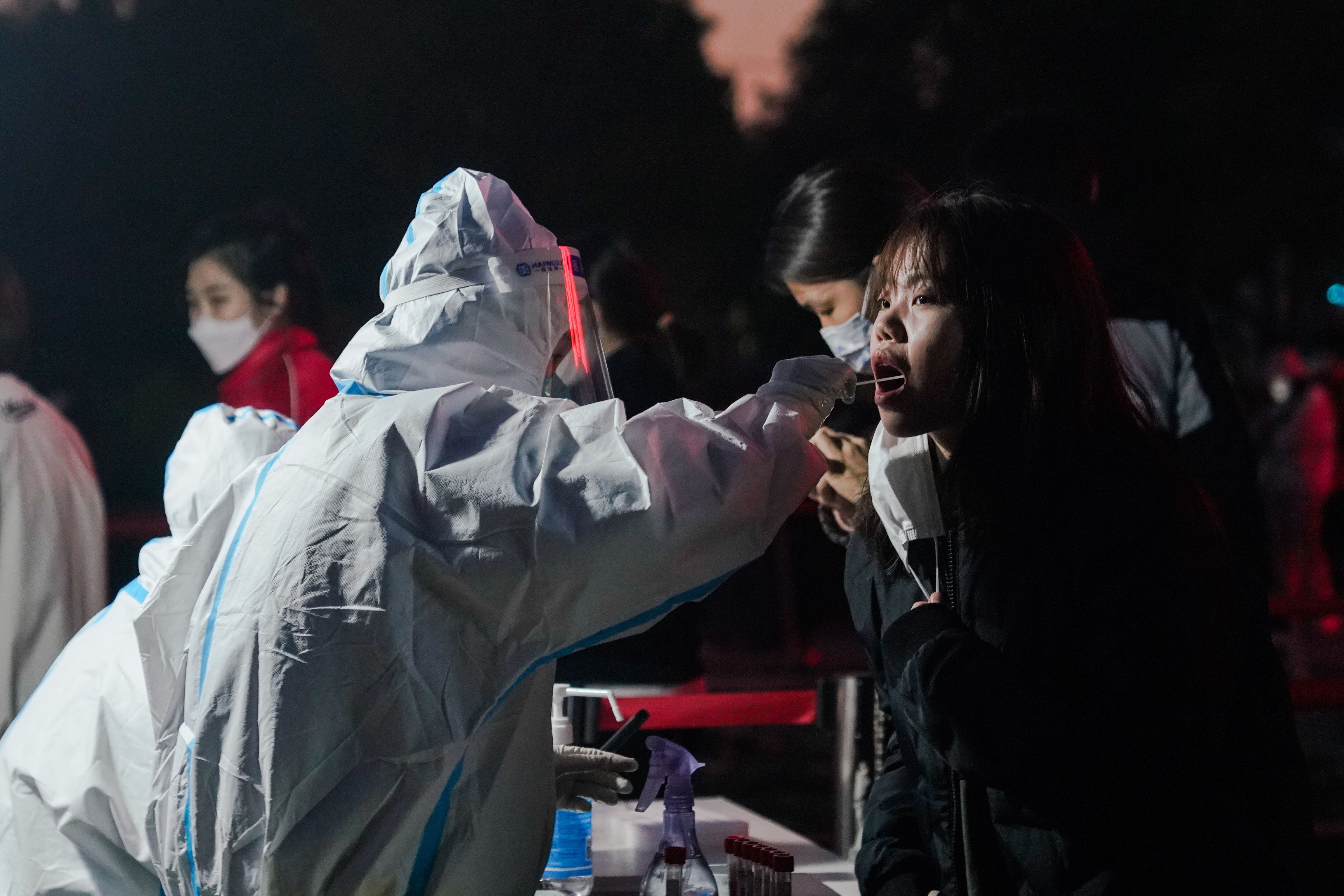 Un trabajador sanitário hace una prueba PCR en un mujer en Pekín, China, en una foto de 14 de noviembre. EFE/EPA/WU HAO 