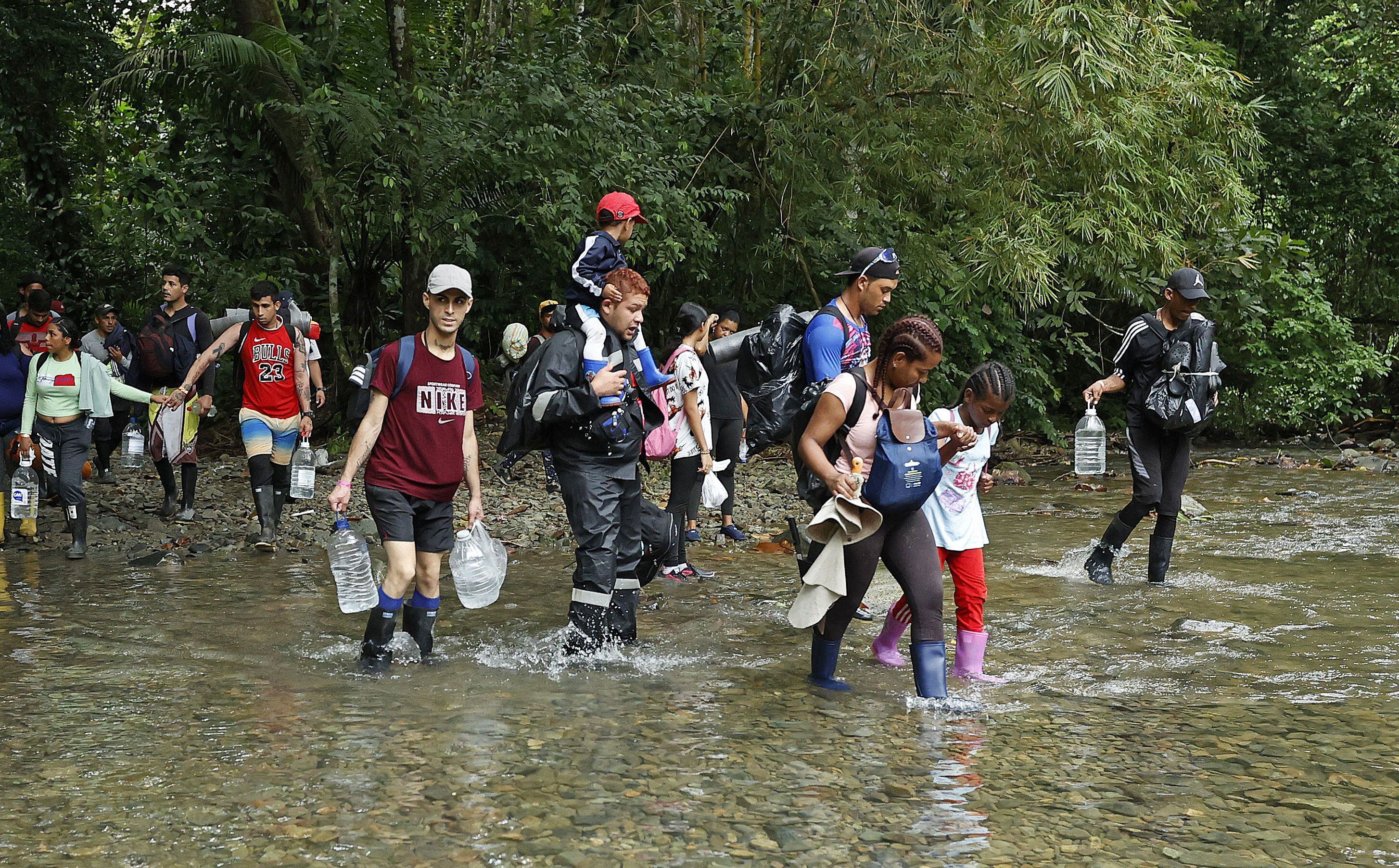 Migrantes atraviesan un río con la intención de llegar a Panamá, el 8 de octubre de 2022, a través del Tapón del Darién (Colombia). EFE/Mauricio Dueñas Castañeda 