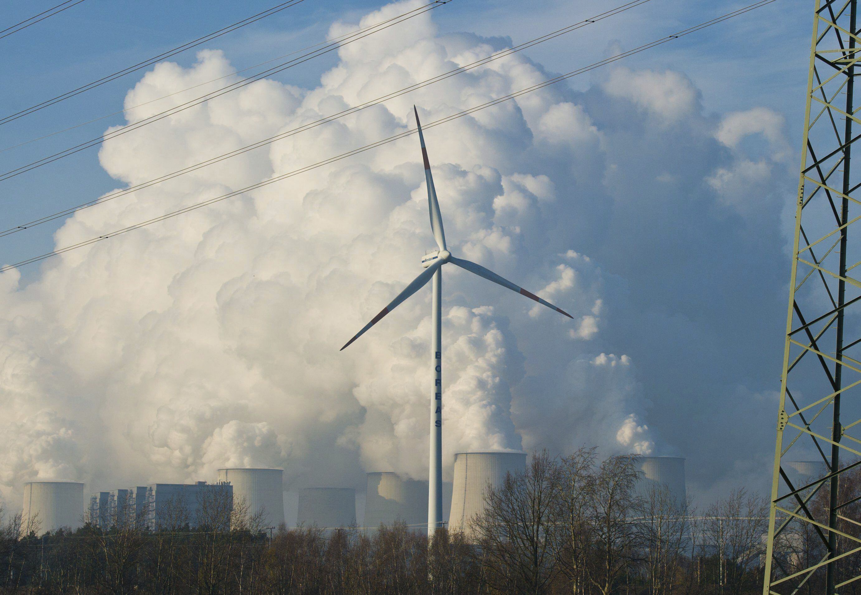 Una turbina de energía eólica en frente de las torres de una planta de energía en Alemania, en una fotografía de archivo. EFE/PATRICK PLEUL 