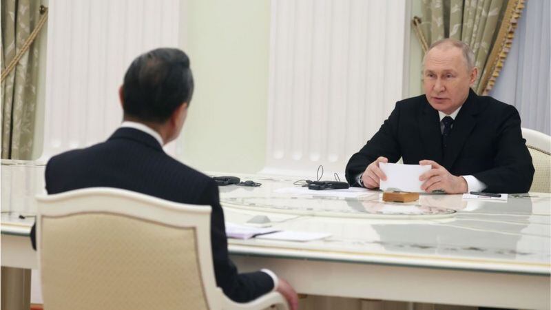 EPA Una misma mesa, dos formas de sentarse. El jefe de la diplomacia china, Wang Yi y el presidente ruso, Vladimir Putin.