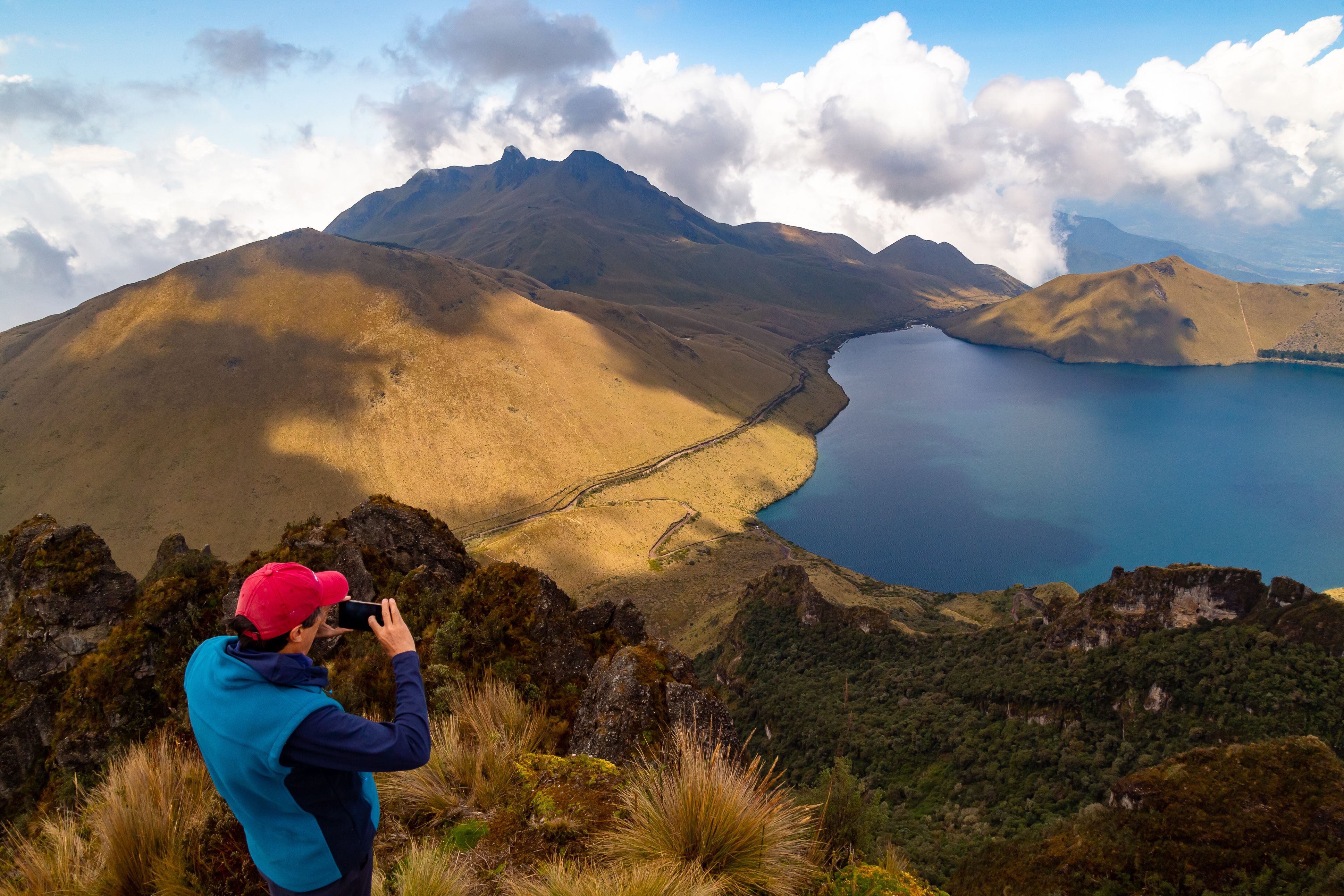 Mojanda, Tabacundo, Ecuador, 9 de enero de 2022: Un montañista toma fotos del paisaje de las lagunas de Mojanda y la colina de Fuya Fuya en un día soleado a principios de 2022.