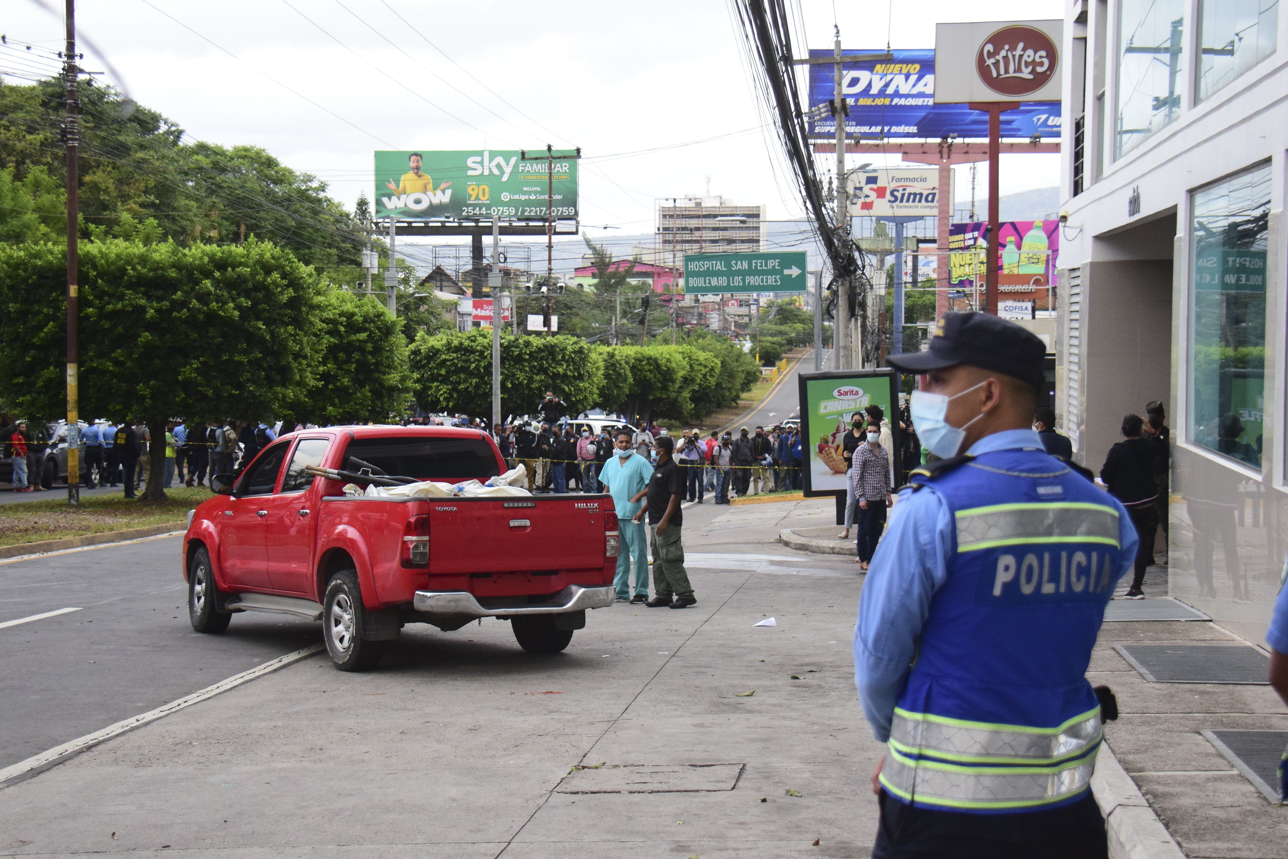 Policías y expertos forenses realizan el levantamiento de cuatro personas asesinadas en la madrugada de hoy, a la salida del estacionamiento de un edificio donde funcionan locales comerciales y residenciales, en Tegucigalpa (Honduras). EFE/STR 