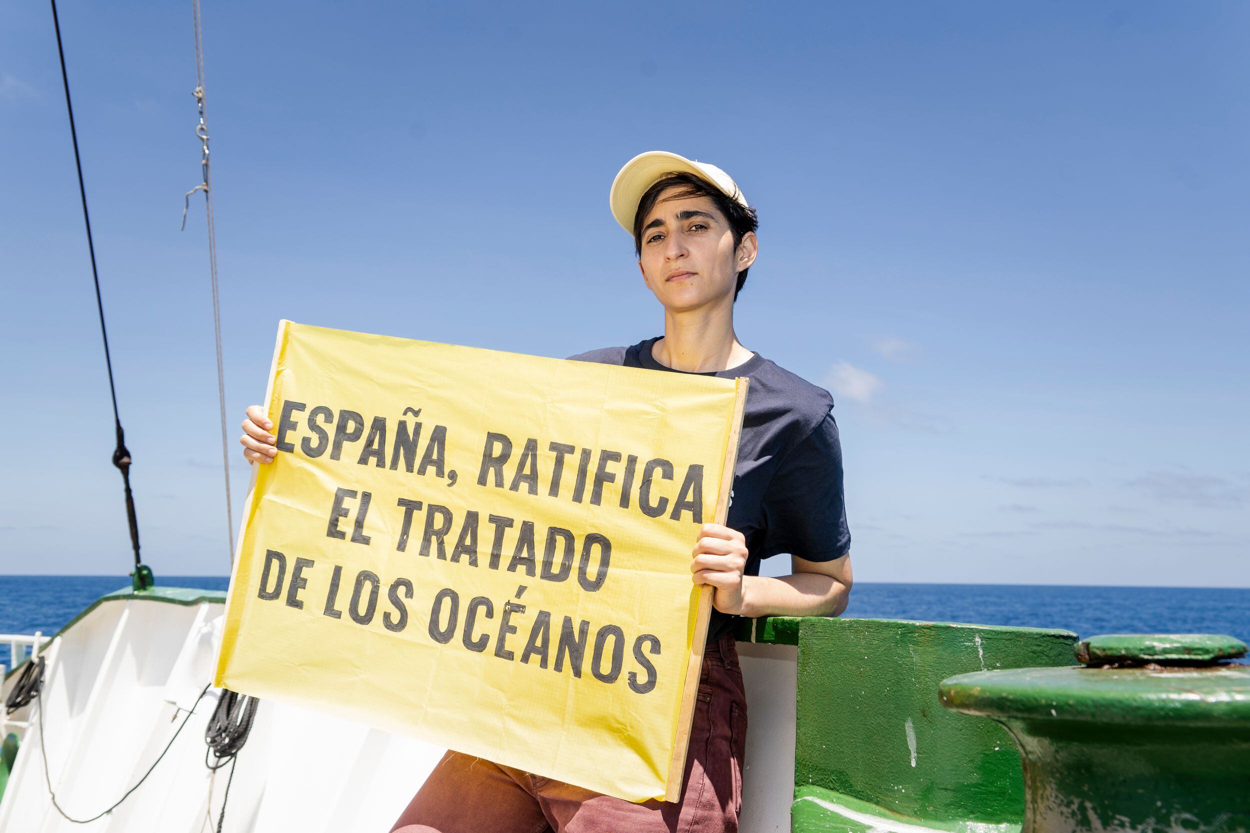 Flores con un cartel en el que conmina a que España ratifique el Tratado Global de los Océanos, durante una expedición científica de la organización ecologista a las islas Galápagos. EFE. 