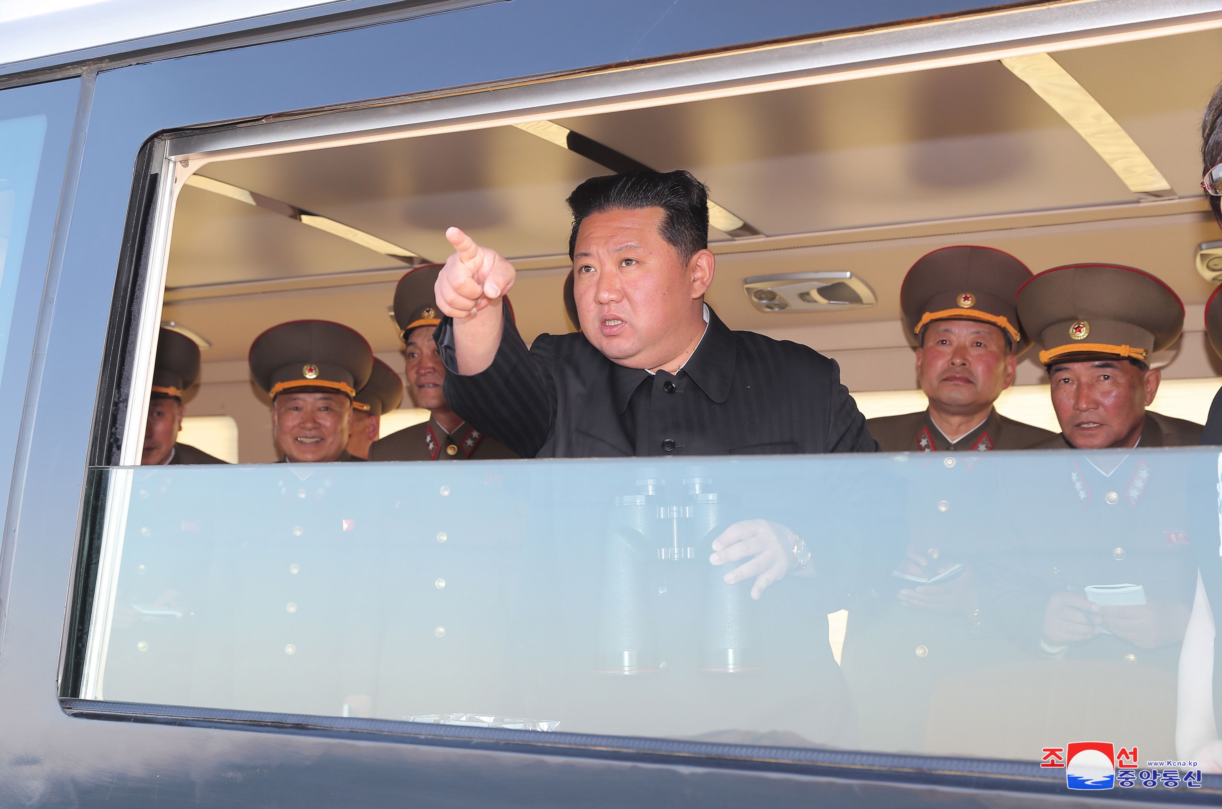 Una foto publicada por la Agencia Central de Noticias de Corea del Norte (KCNA) muestra a Kim Jong Un (c), líder de Corea del Norte, mientras observaba la prueba de fuego de un arma guiada táctica de nuevo tipo desde una ubicación no revelada, lanzada el 16 de abril de 2022.
