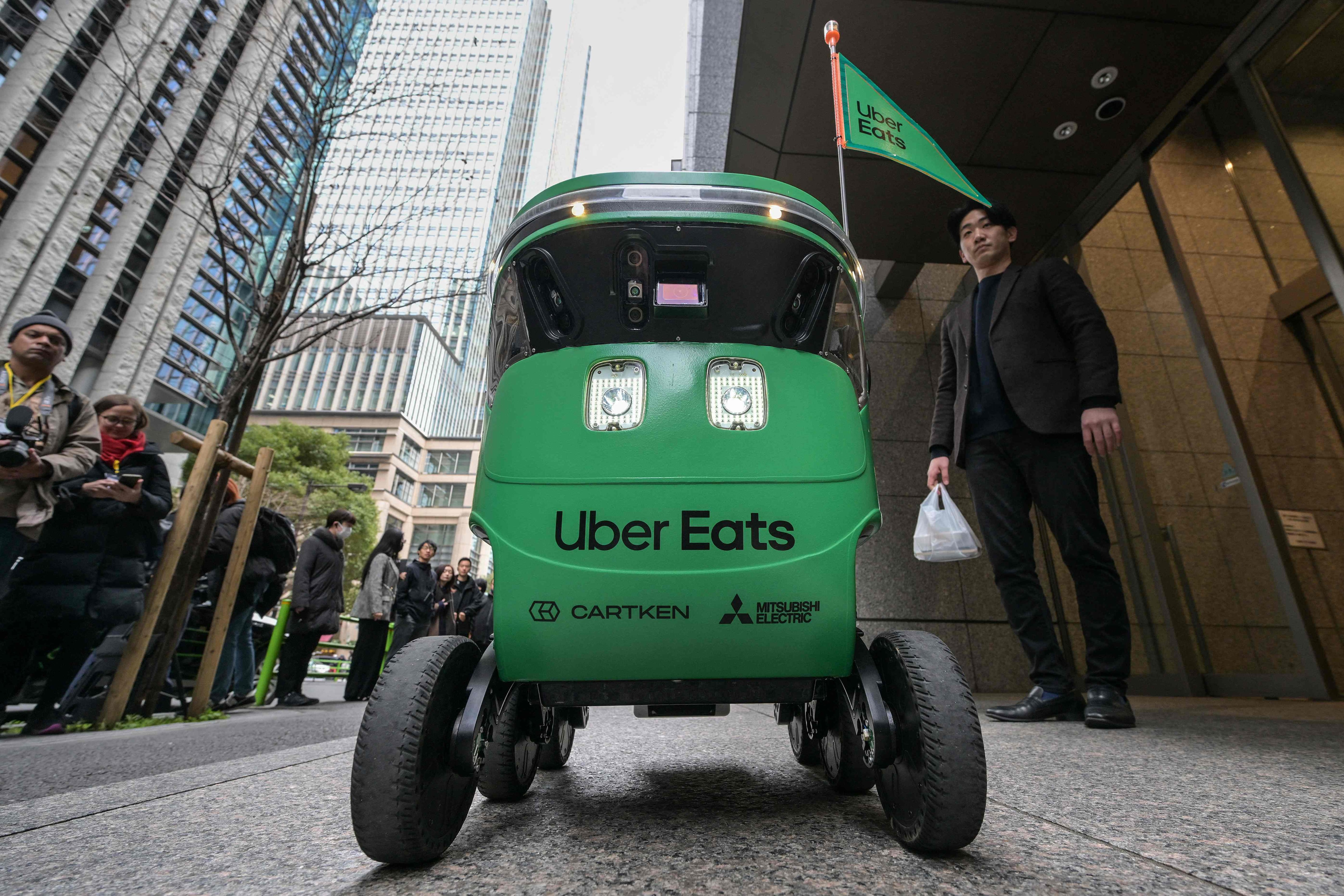 Los miembros de los medios esperan el inicio de una demostración de un servicio de entrega de robots de Uber Eats Japan.