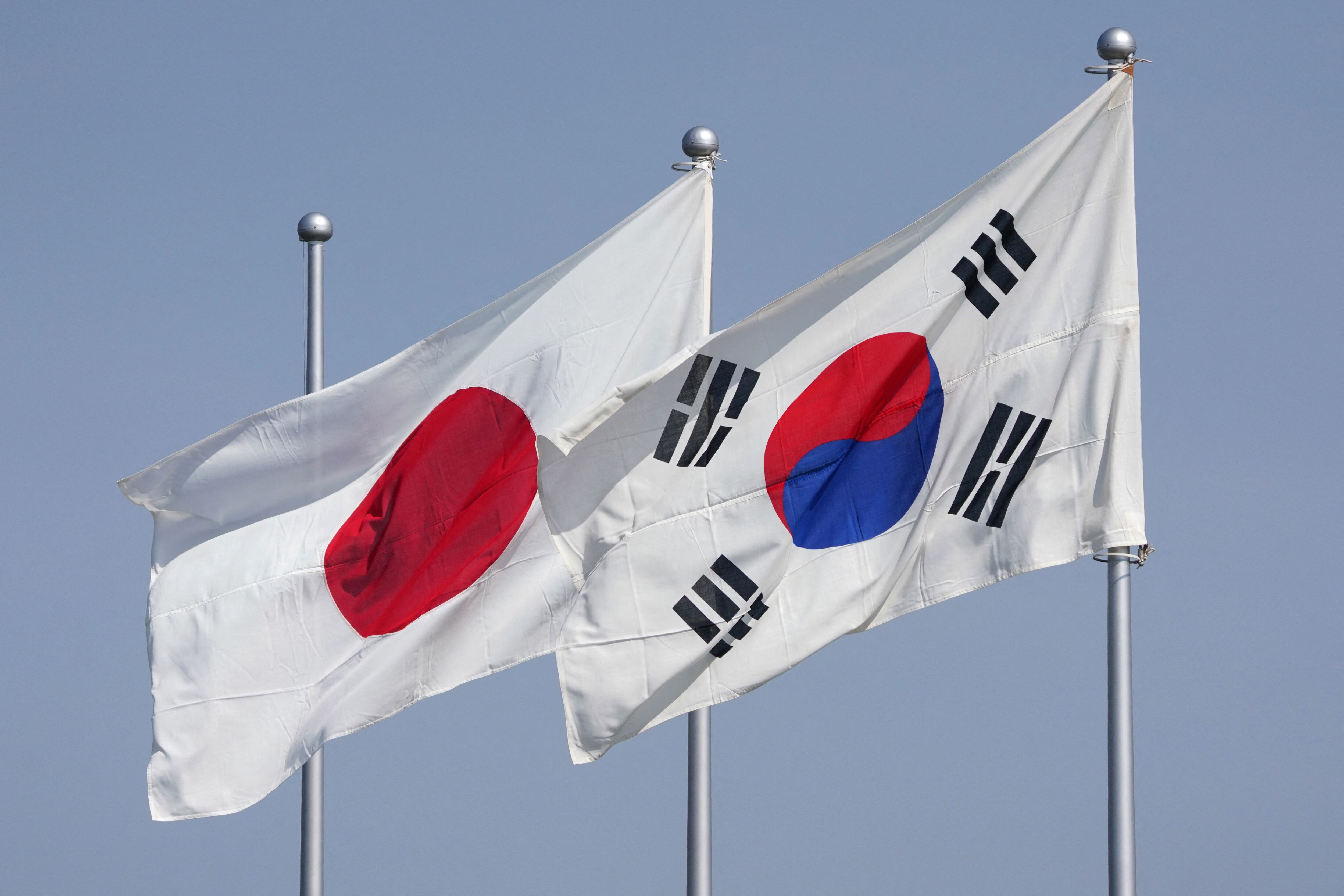 Las banderas nacionales de Japón (i) y Corea del Sur (d) ondean al viento antes de la llegada del presidente de Corea del Sur, Yoon Suk Yeol, al aeropuerto Haneda de Tokio el 16 de marzo de 2023. Estaba previsto que Yoon llegara a Tokio para una cumbre destinada a impulsar los lazos frente a la creciente agresión de Pyongyang.