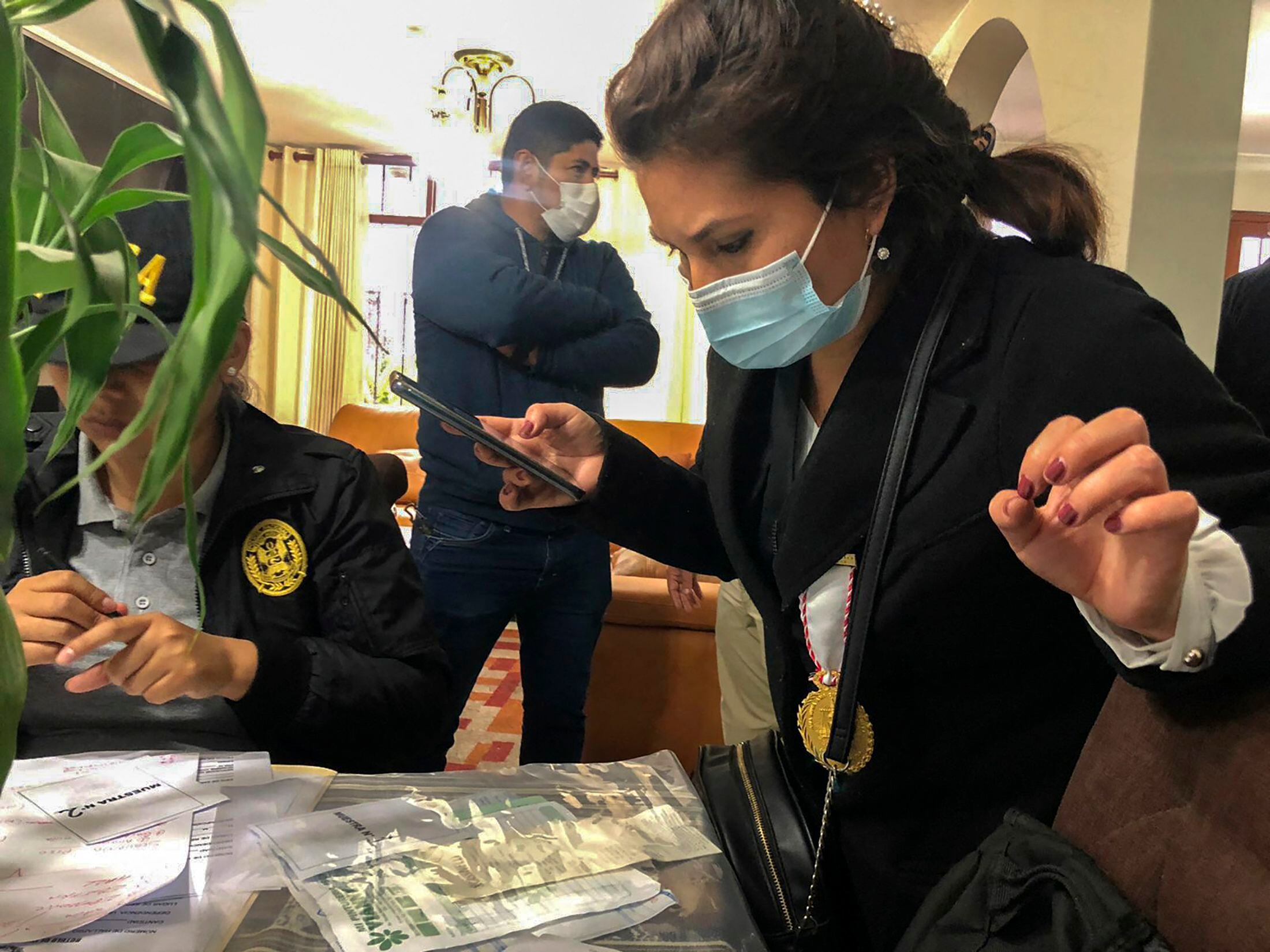 Fiscales y policías realizando un allanamiento en la casa de la hermana del presidente peruano Pedro Castillo, Gloria Castillo, mientras buscan a su sobrino, Gianmarco Castillo, como parte de un caso de corrupción, en Lima a 11 de octubre de 2022.