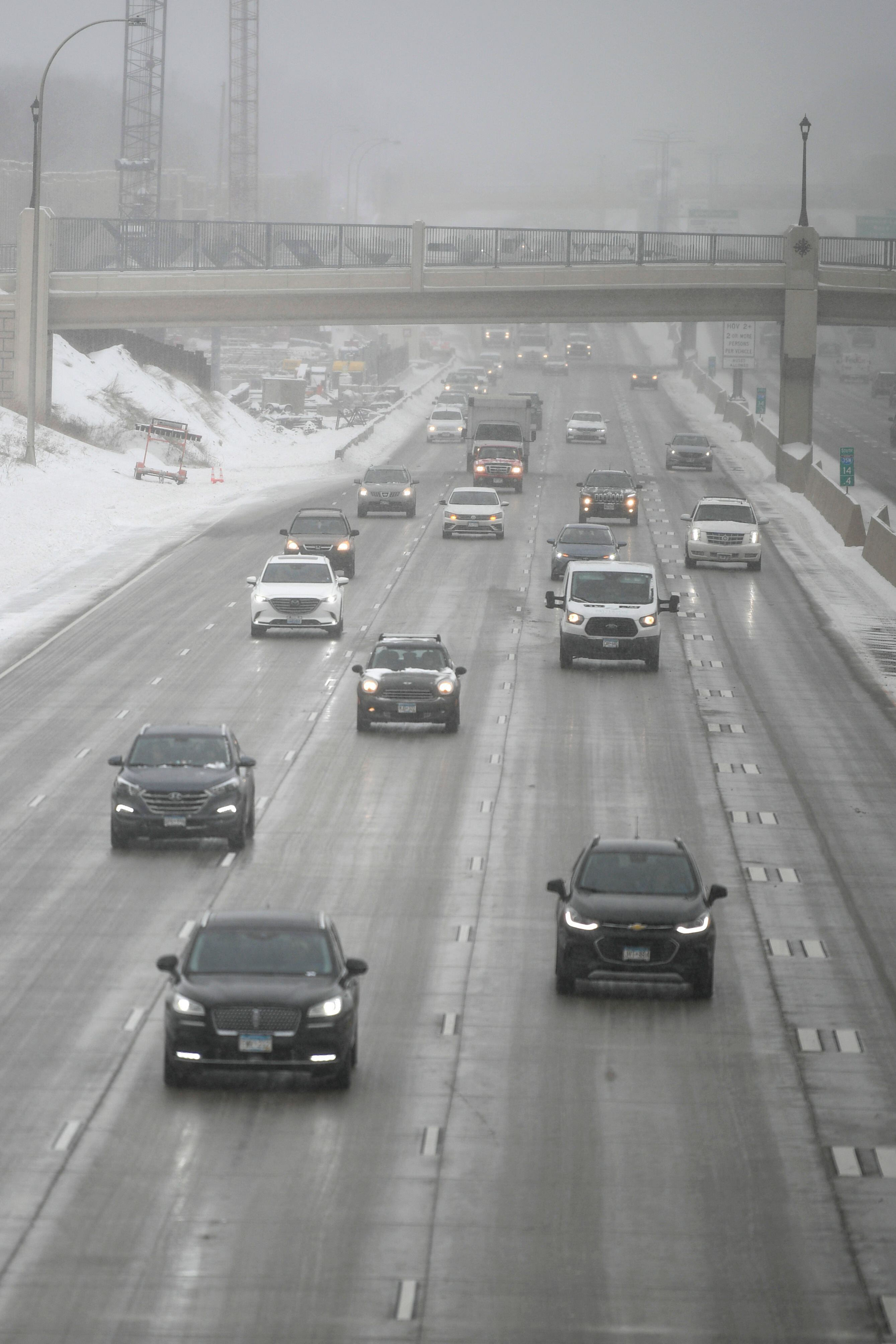 El tráfico se mueve en la carretera interestatal 35W durante una tormenta de nieve en Minneapolis, Minnesota, el 22 de febrero de 2023. Poderosas tormentas invernales azotaron los Estados Unidos el miércoles, con fuertes nevadas que atravesaron amplias áreas, incluso cuando se esperaba un calor inusual en otras.
