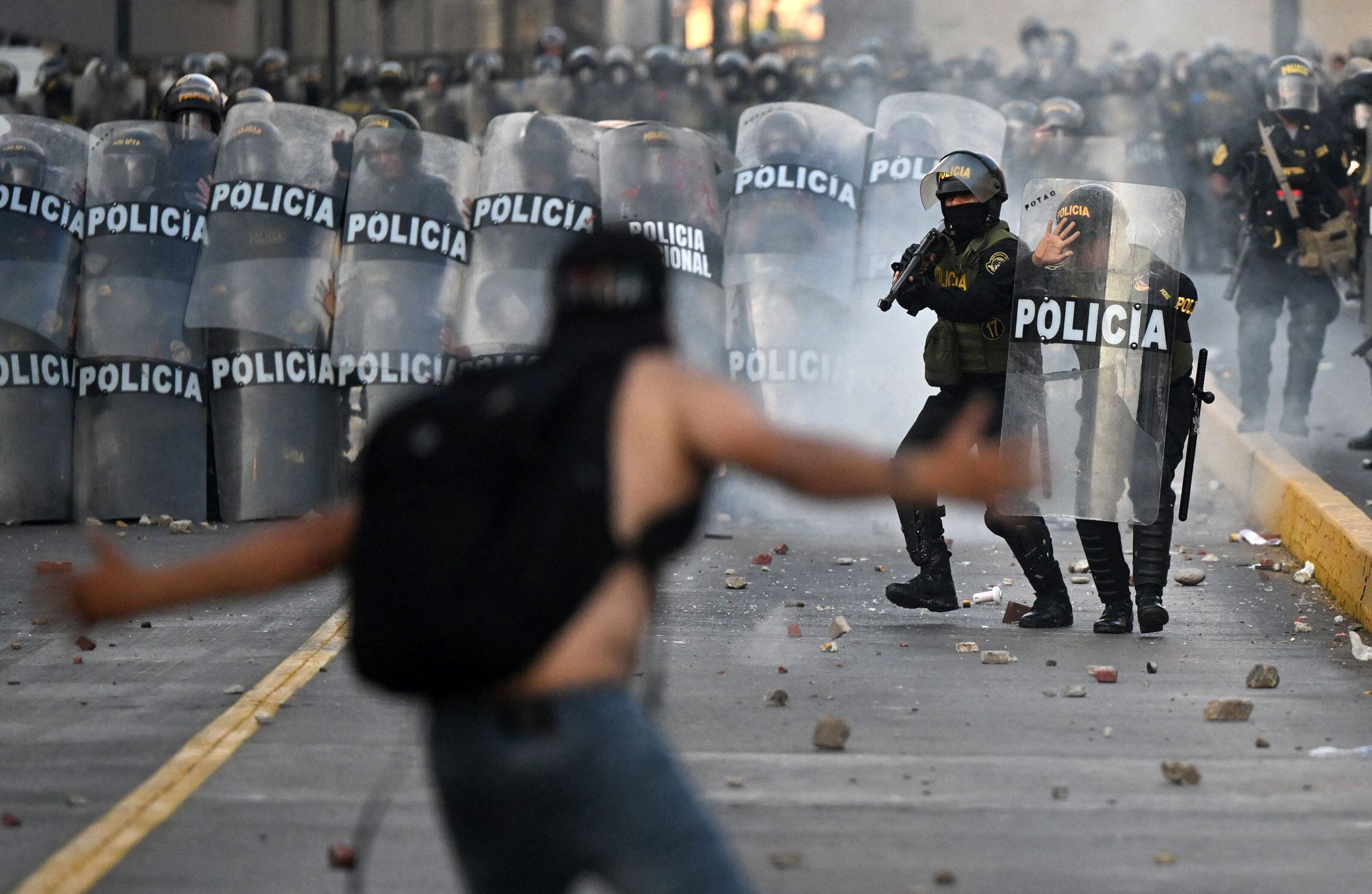 Manifestante se enfrenta a policías en Lima.