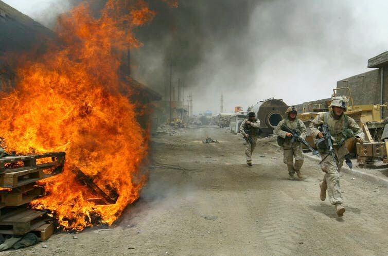 En esta foto de 2004, los marines estadounidenses queman sus fortificaciones en posiciones de primera línea en Faluya, Irak, mientras se retiran de la ciudad. (AP Photo/John Moore)