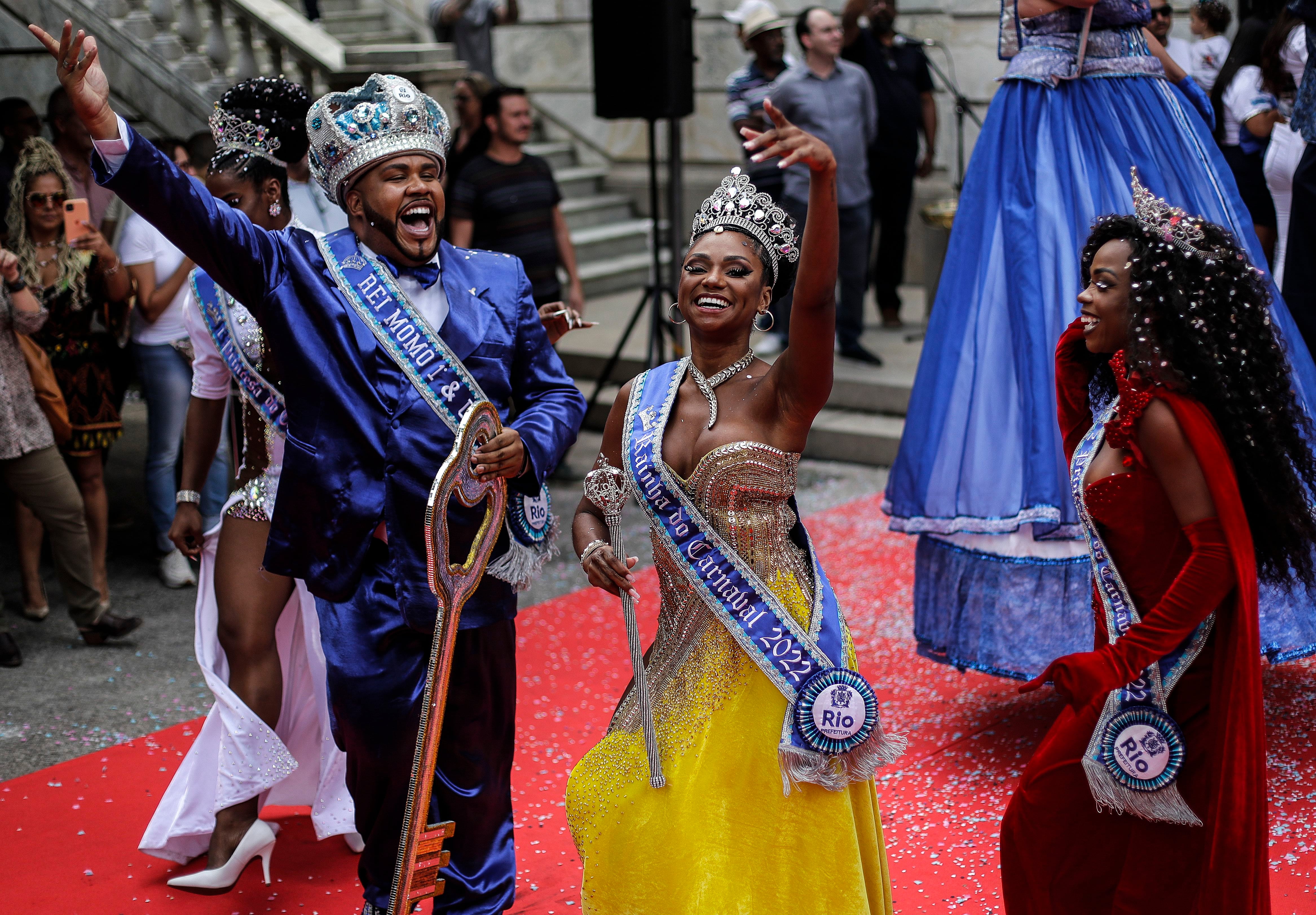 El Rey Momó (i), junto a la reina Bianca Monteiro (c) y la princesa del carnaval, celebra mientras sostiene la llave de la ciudad luego de recibirlas de parte del alcalde de Río, Eduardo Paes (fuera de cuadro), este 20 de abril de 2022, durante la inauguración oficial del Carnaval 2022, en Río de Janeiro (Brasil).