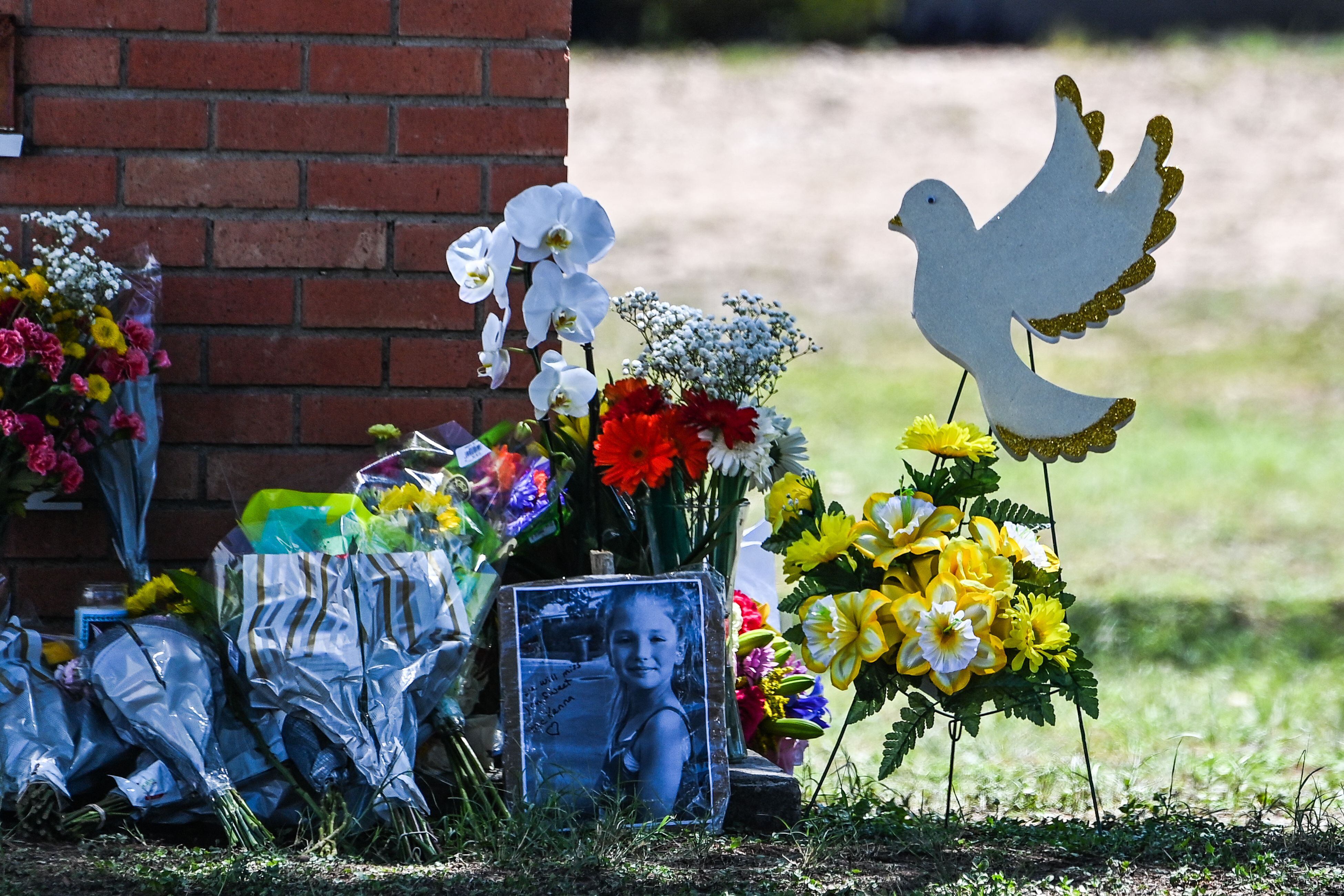 La foto de una niña pequeña, víctima del tiroteo, se ve junto a las flores colocadas en un monumento improvisado frente a la Escuela Primaria Robb en Uvalde, Texas, el 25 de mayo de 2022. (Foto de CHANDAN KHANNA / AFP)