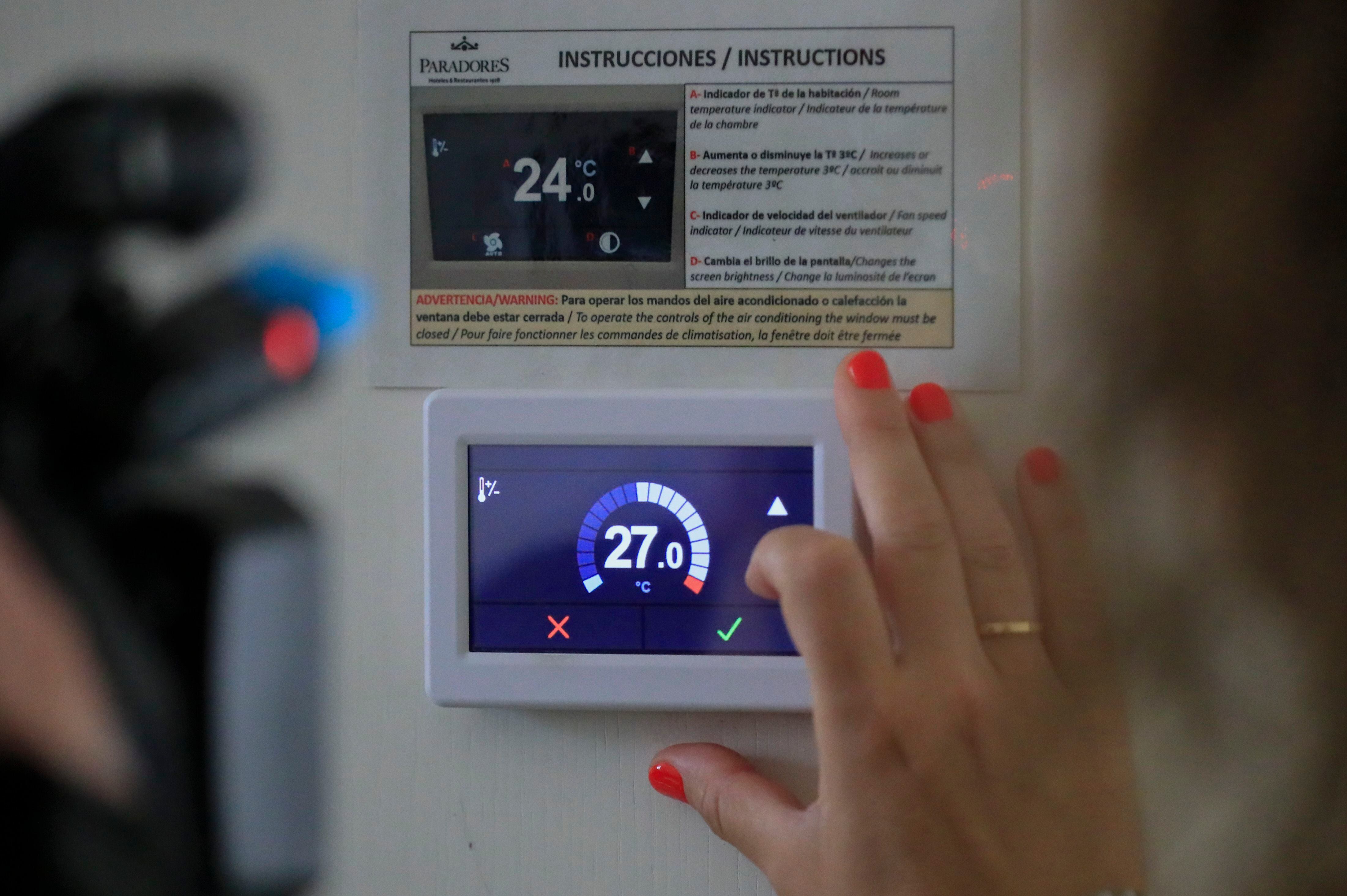 Una mujer ajusta la temperatura a 27 grados en una de las estancias del Parador de Alcalá de Henares este miércoles, cuando empiezan a aplicarse las medidas de ahorro energético como el ajuste de termostatos. EFE/ Fernando Alvarado 