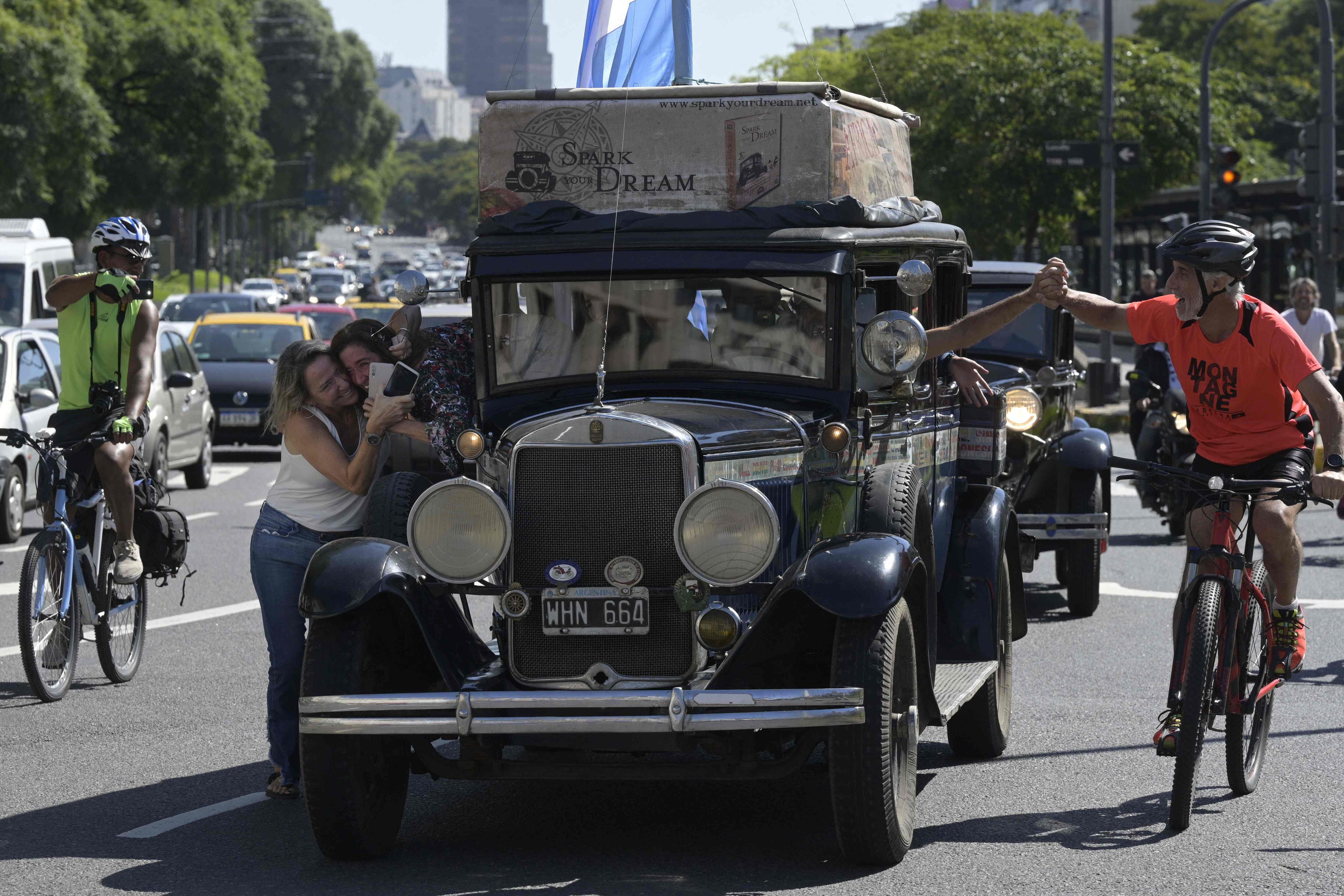 La familia argentina Zapp monta su auto, un Graham-Paige de 1928, en la avenida 9 de Julio en Buenos Aires, el 13 de marzo de 2022 para terminar un viaje de 22 años alrededor del mundo que comenzó el 23 de enero de 2000. (Foto por JUAN MABROMATA / AFP)