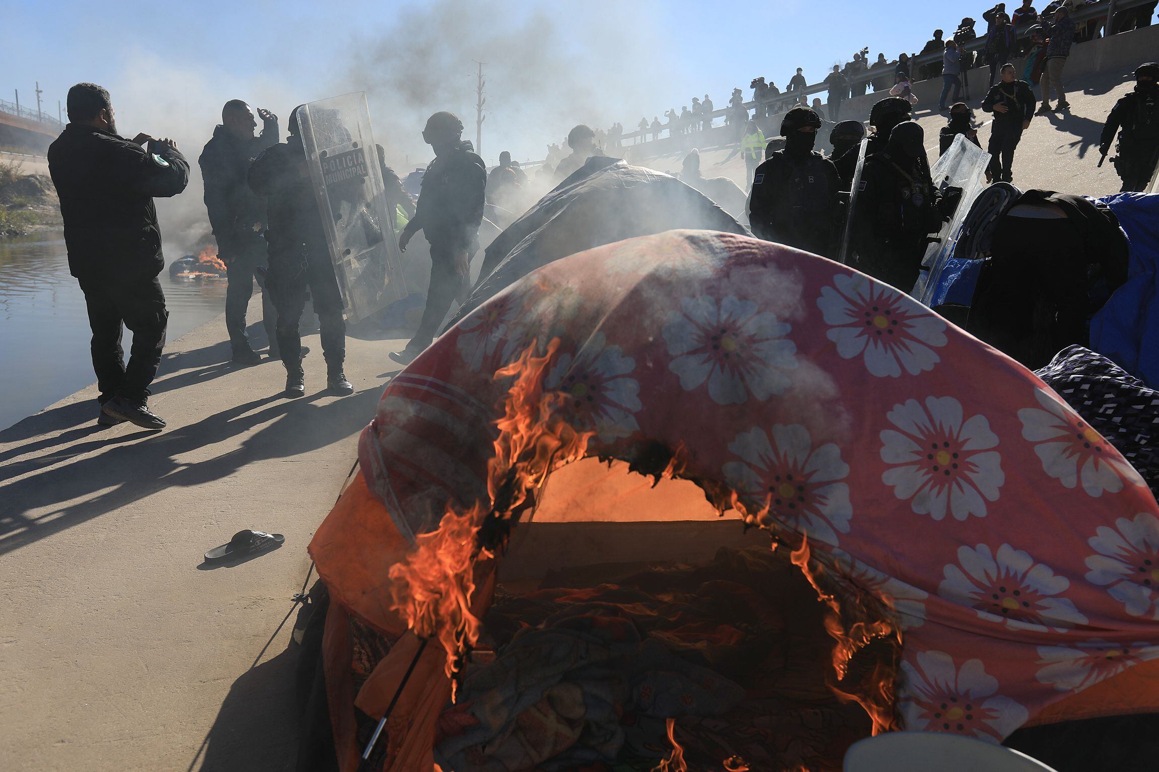 Fotografía de una tienda de campaña incendiada durante un enfrentamiento entre migrantes venezolanos y grupos antimotines hoy, en la fronteriza Ciudad Juárez, Chihuahua (México).