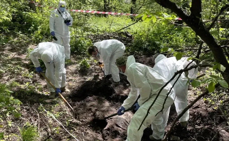 Un equipo forense de Ucrania remueve los restos de un joven soldado enterrado a la afueras de Kiev.