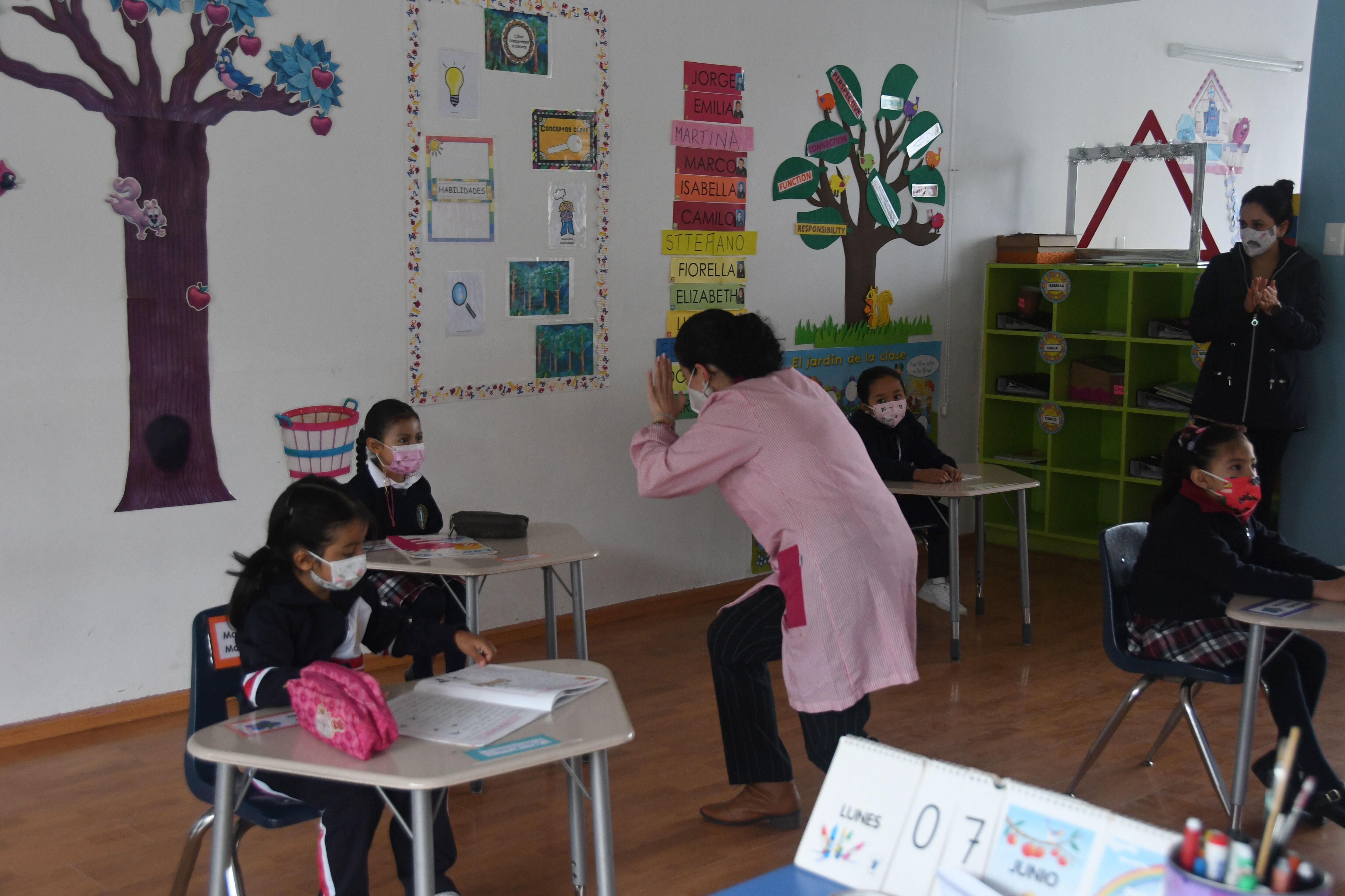 QUITO. Alumnos del colegio SEK en sus clases presenciales, tras 15 meses de pandemia. Una profesora interactúa con los estudiantes que acudieron este lunes como parte del retorno voluntario a las aulas en Ecuador.