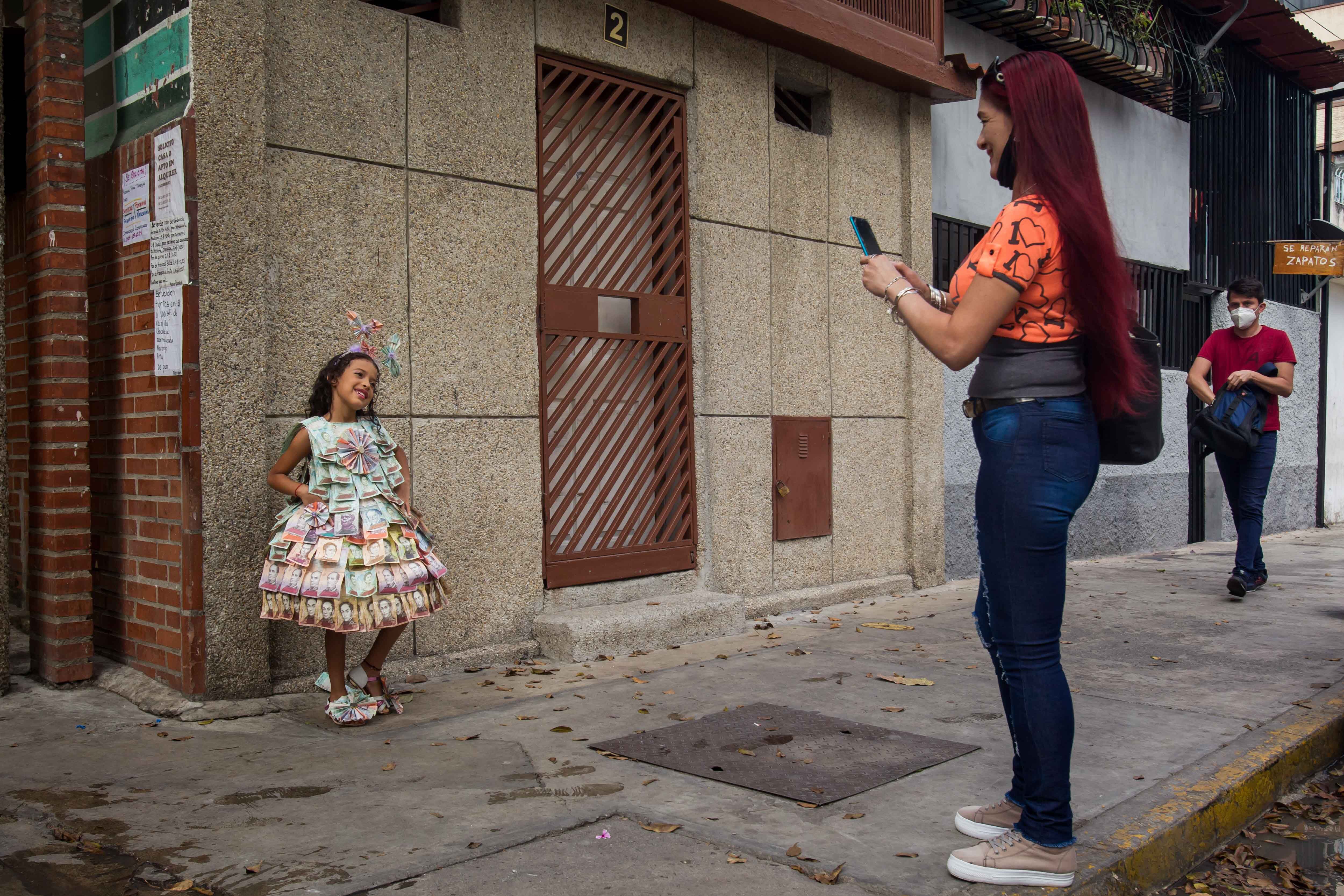 La niña Nazareth Yanez posa para una fotografía mientras usa un vestido hecho con billetes, el 1 de marzo del 2022, en Caracas (Venezuela). EFE/Miguel Gutiérrez 