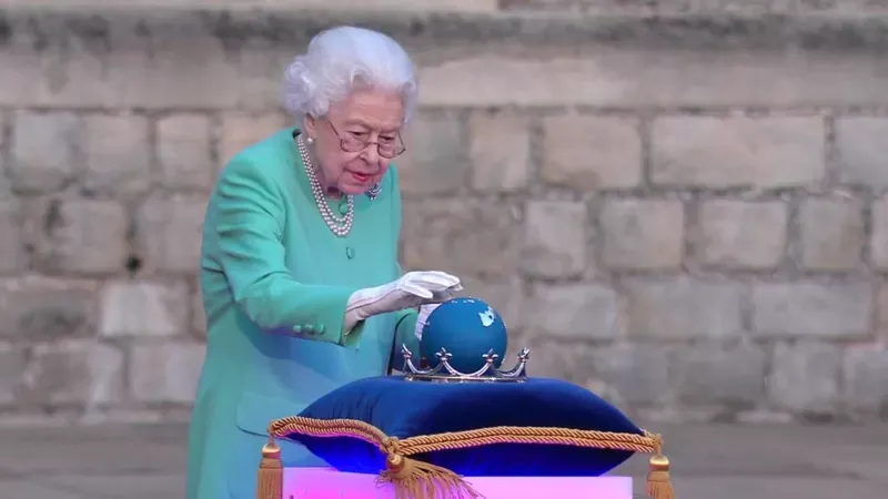 La reina toca un globo terráqueo para encender el "Árbol de los árboles". Getty Images