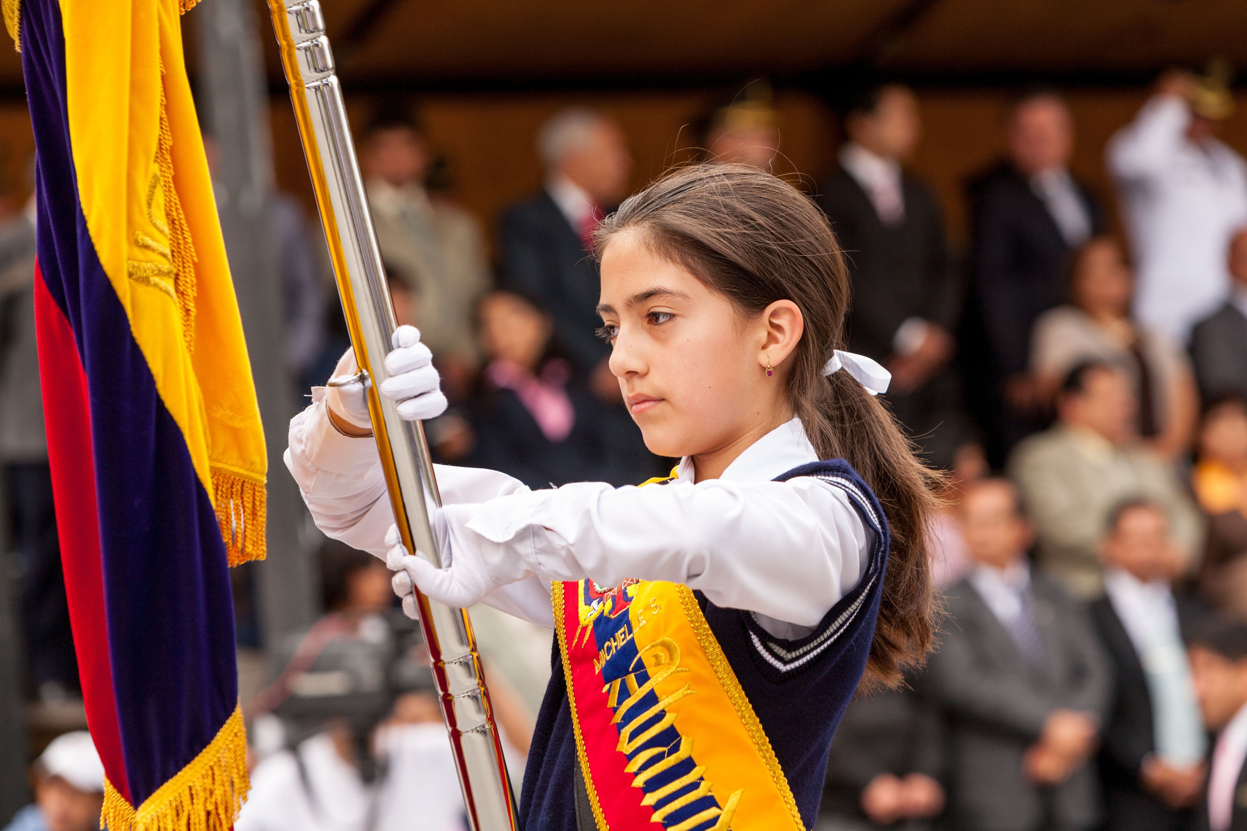 Una estudiante abanderada en la ceremonia del Día de la Bandera Nacional, en Baños de Agua Santa, Ecuador.