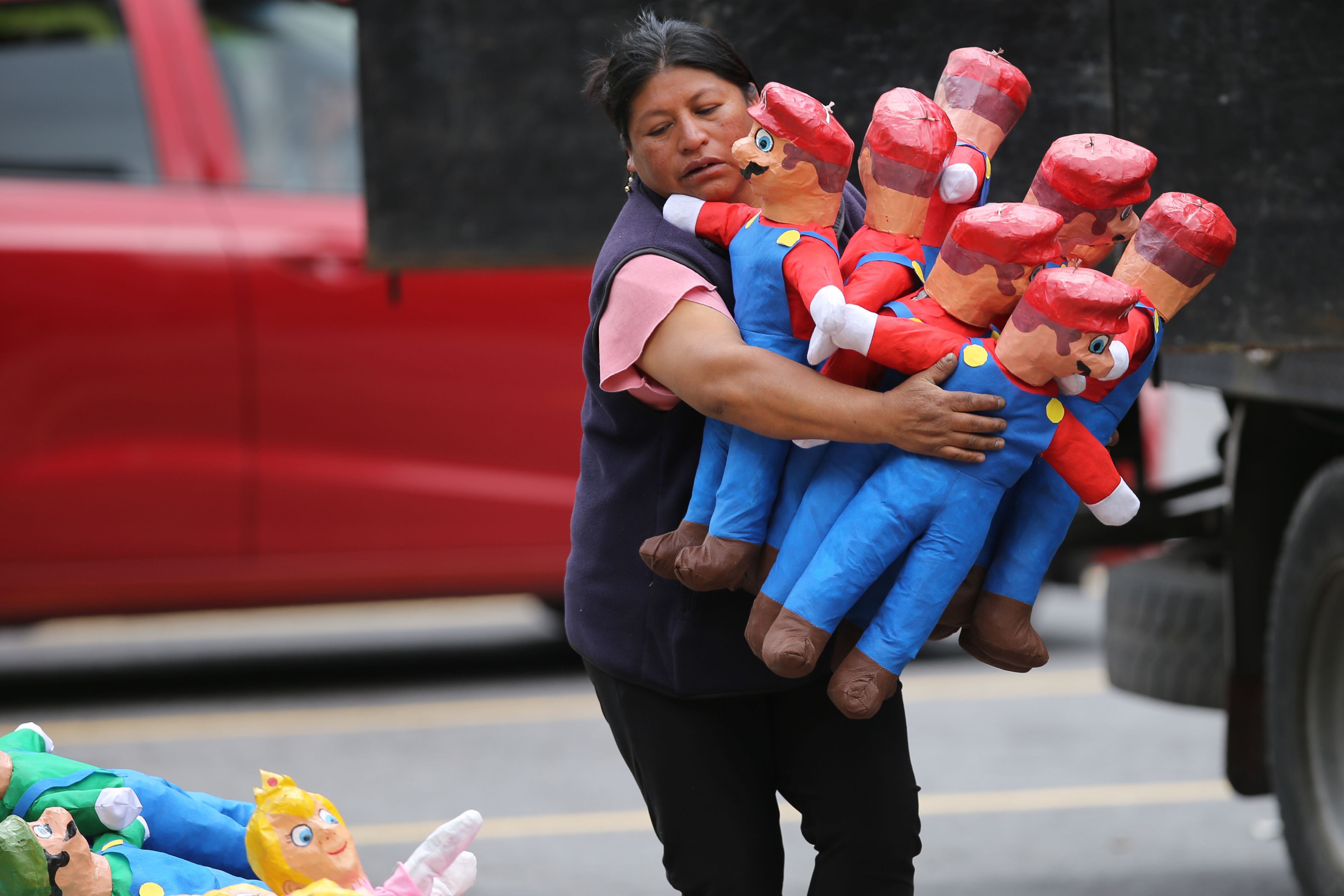 Fotografía de "monigotes" o muñecos de personajes políticos y ficticios puestos a la venta en una calle, hoy en Quito (Ecuador). EFE/ Julio Estrella
