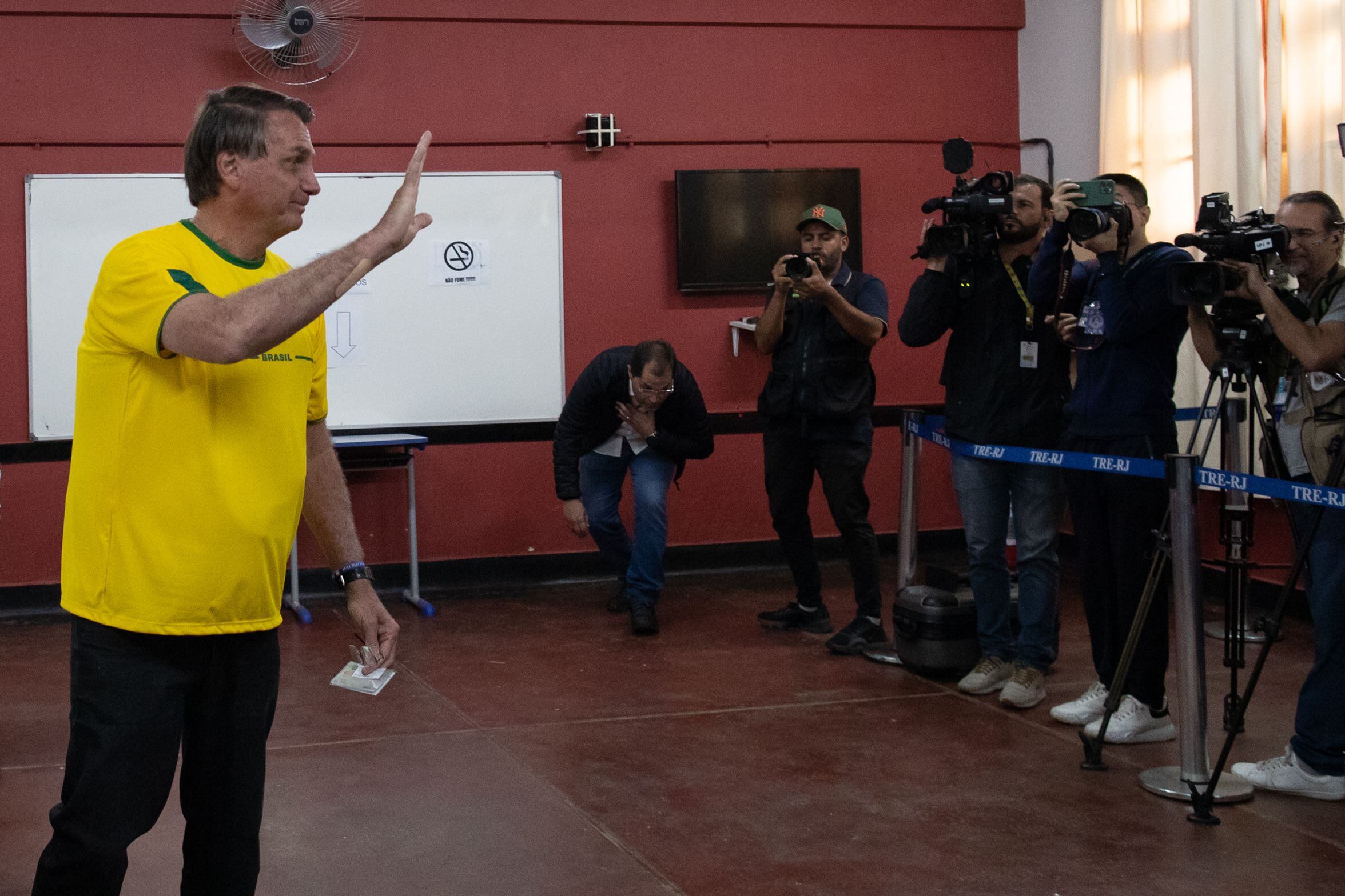 El presidente brasileño Jair Bolsonaro saluda tras votar hoy, en un puesto de votación en Río de Janeiro (Brasil). EFE/ Andre Coelho POOL 