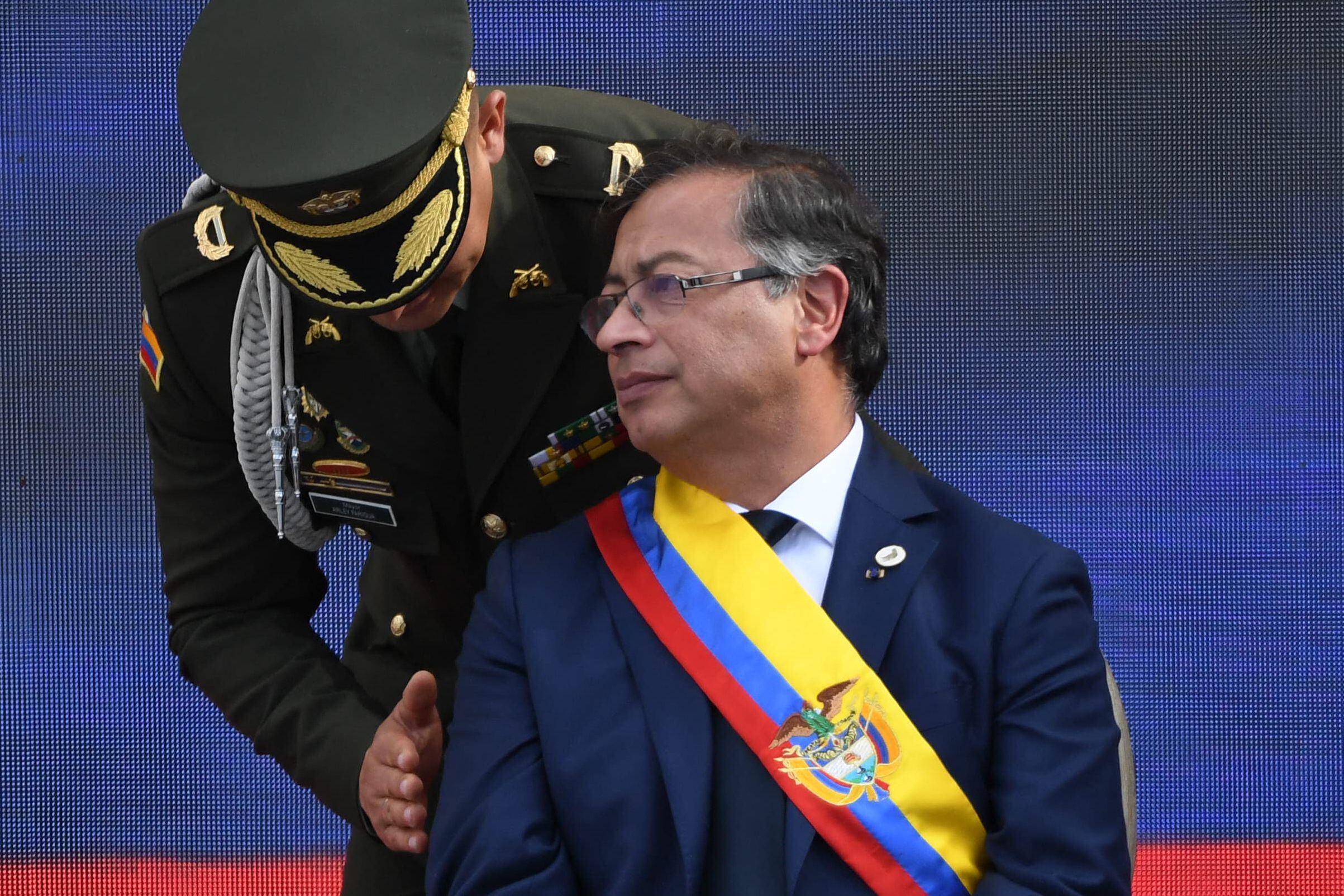 El nuevo presidente de Colombia, Gustavo Petro, escucha al alcalde de la Policía de Colombia, Arley Farigua, durante la ceremonia de toma de posesión en la plaza Bolívar de Bogotá, el 7 de agosto de 2022. Foto AFP