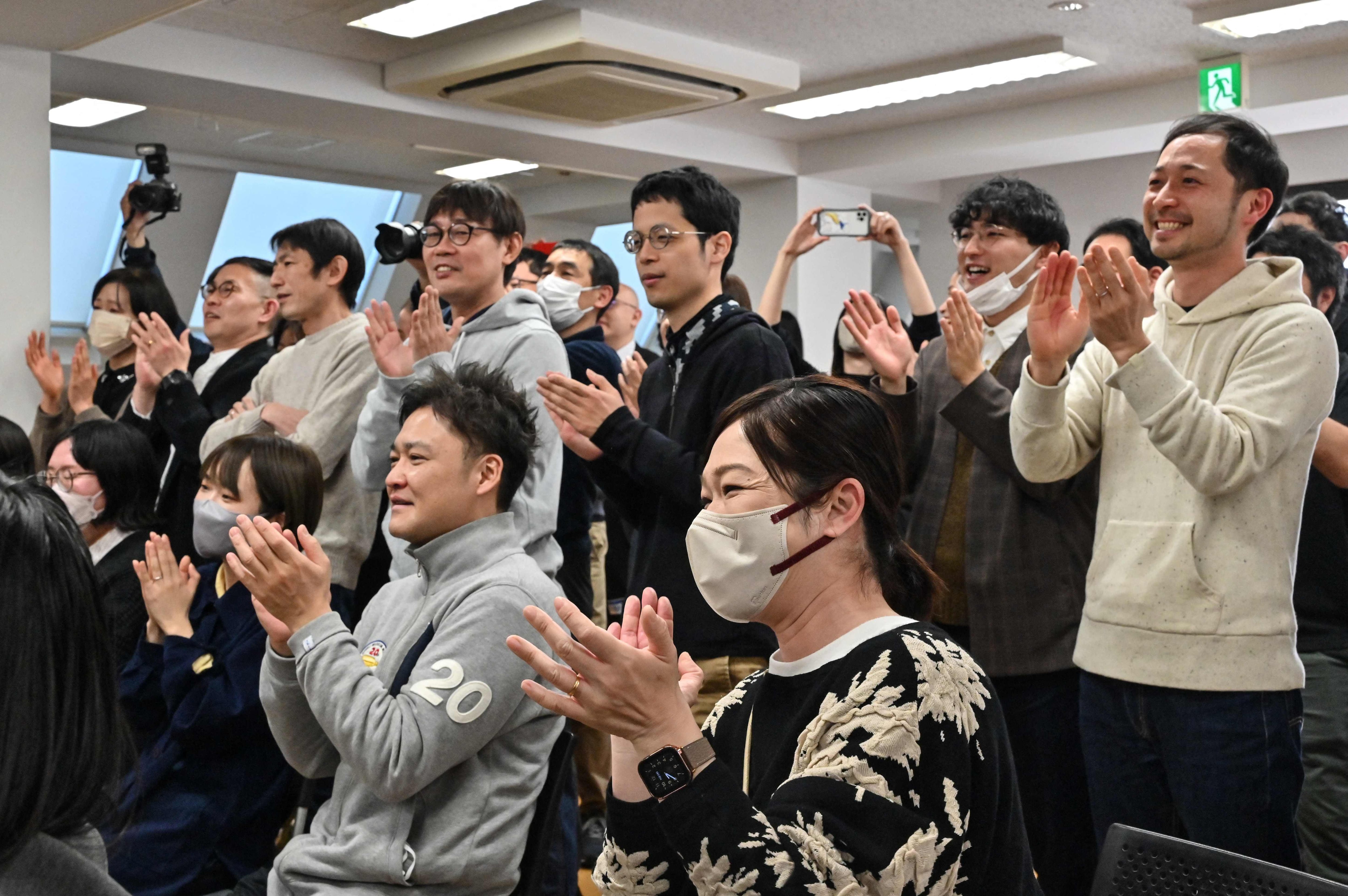 Empleados del estudio japonés Ghibli aplauden al ver la entrega del Óscar a su película animada, 'El chico y la garza', desde las oficinas de la compañía, en Tokio, Japón. 