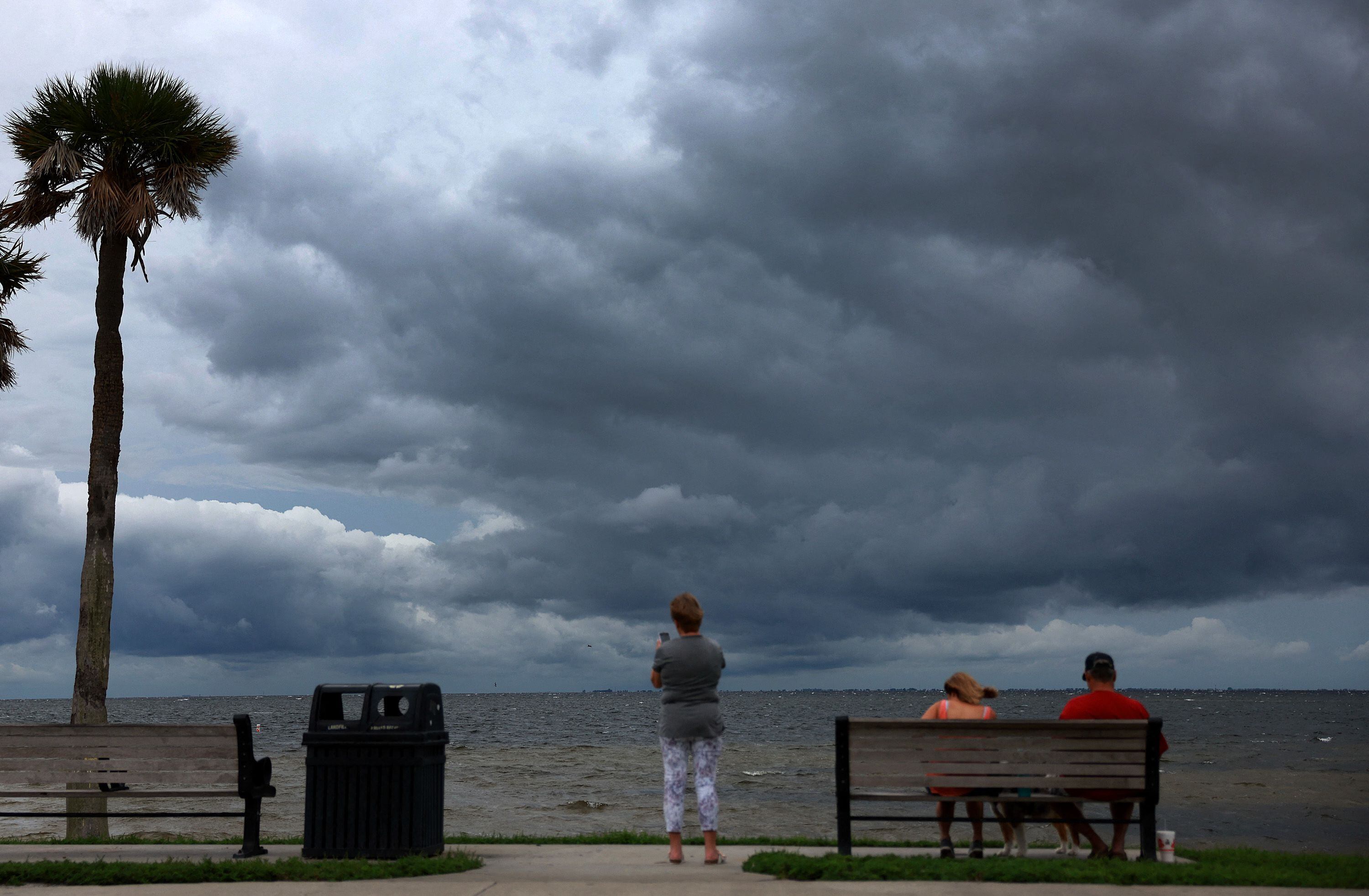 La gente mira cómo las nubes del próximo huracán Ian oscurecen el cielo el 27 de septiembre de 2022 en San Petersburgo, Florida. Se espera que el huracán Ian toque tierra en el área de la Bahía de Tampa desde el miércoles por la noche hasta la madrugada del jueves.