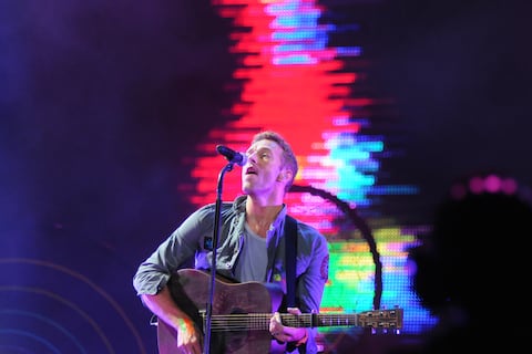 Chris Martin, de Coldplay, se arrodilló en el escenario para ayudar a un asistente que cayó al intentar subirse