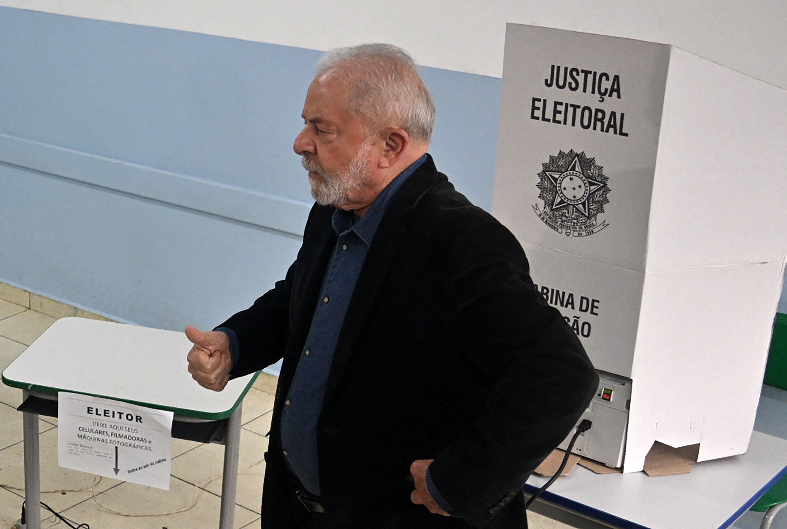 El expresidente brasileño y candidato del izquierdista Partido de los Trabajadores (PT) Luiz Inacio Lula da Silva (C), levanta el pulgar mientras vota durante las elecciones legislativas y presidenciales, en Sao Paulo, Brasil, el 2 de octubre.